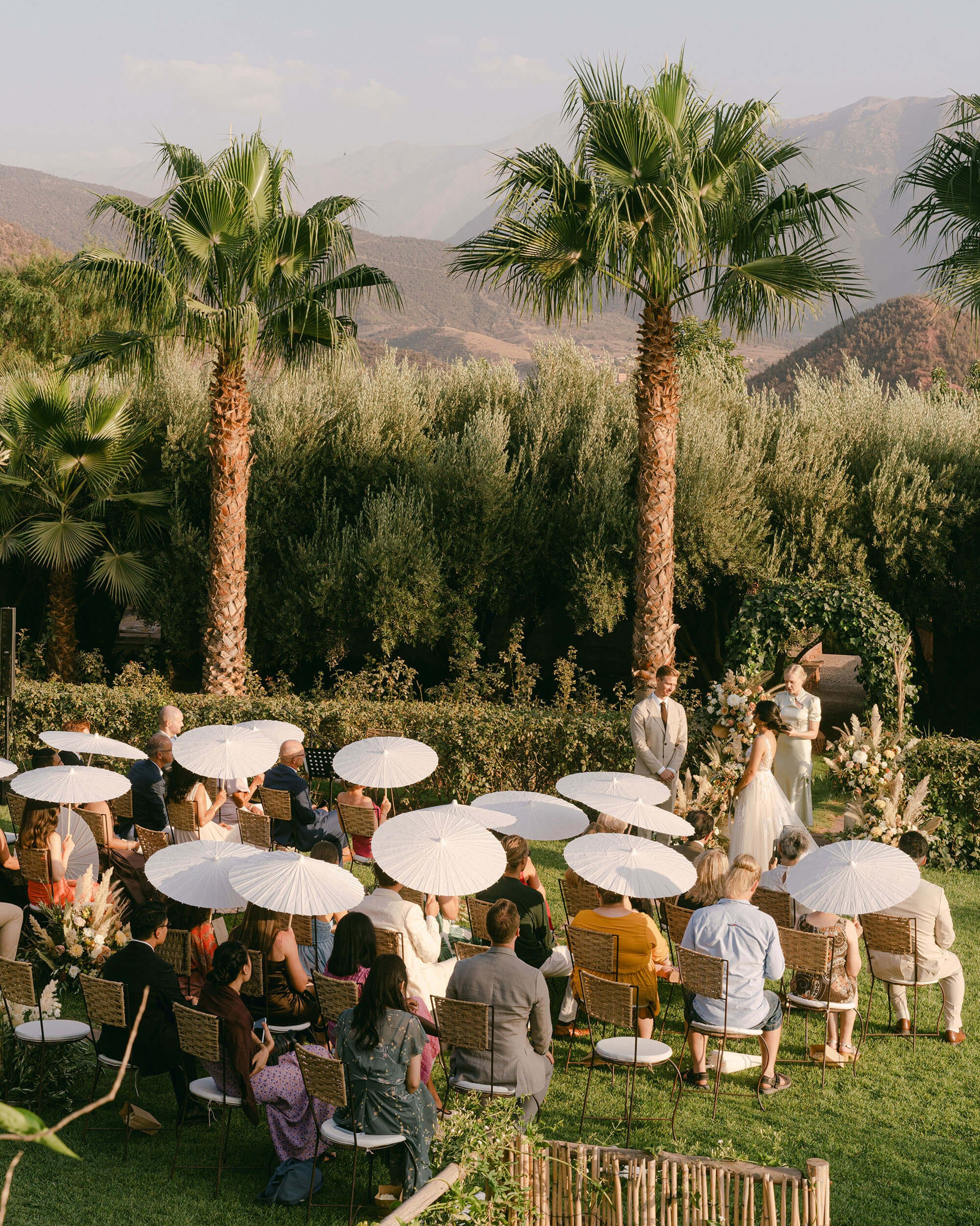 Outdoor wedding ceremony with parasols and mountain views at Kasbah Bab Ourika near Marrakech
