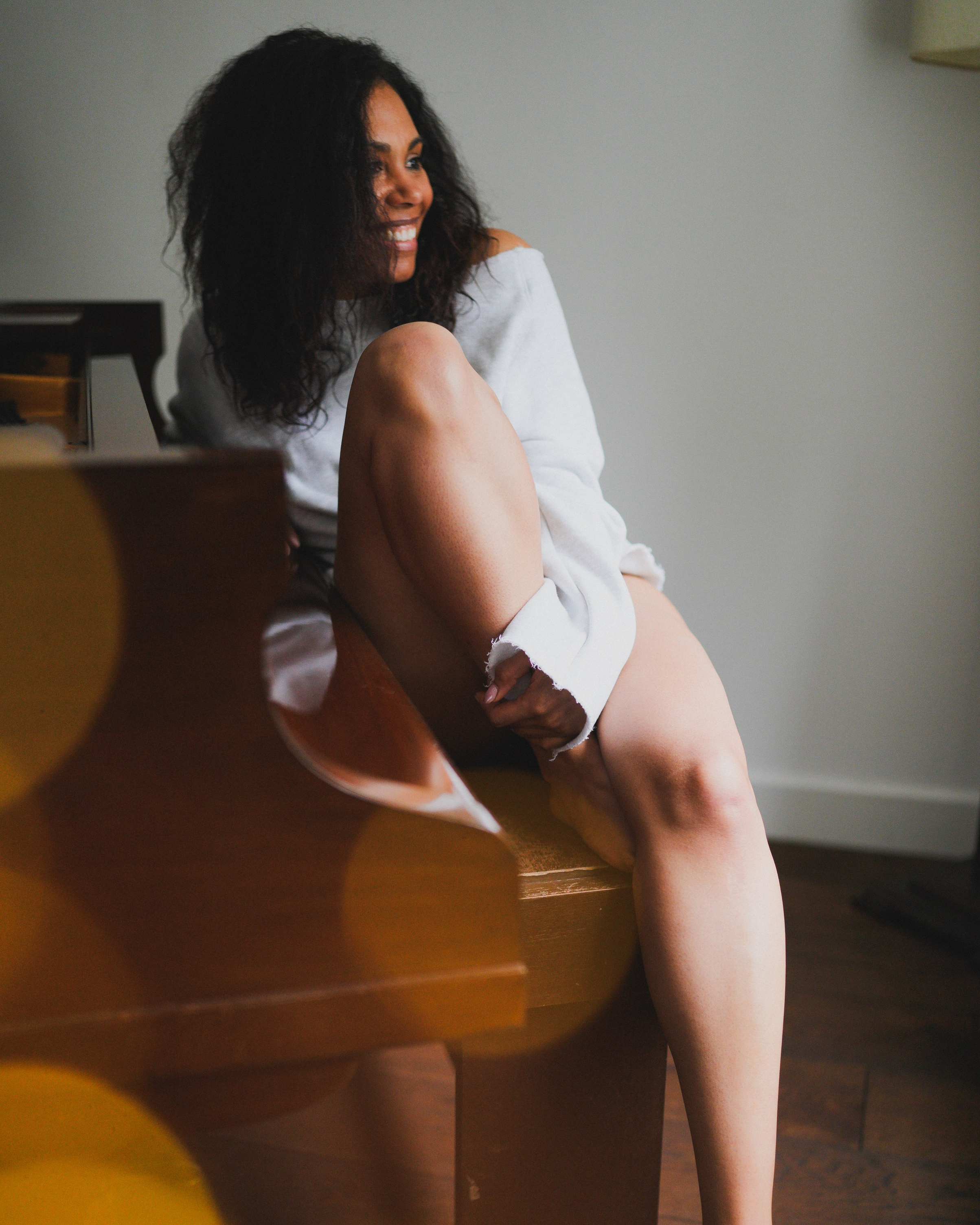 Personal portrait photography of a woman by a window, natural light intimate portrait celebrating confidence and a new chapter.