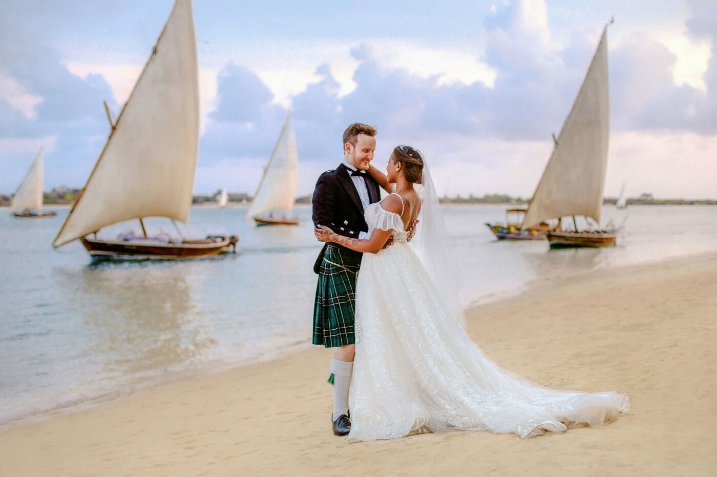 Bride and groom holding hands on a sandbar of Shela Beach Lamu Kenya – elegant destination wedding photo.
