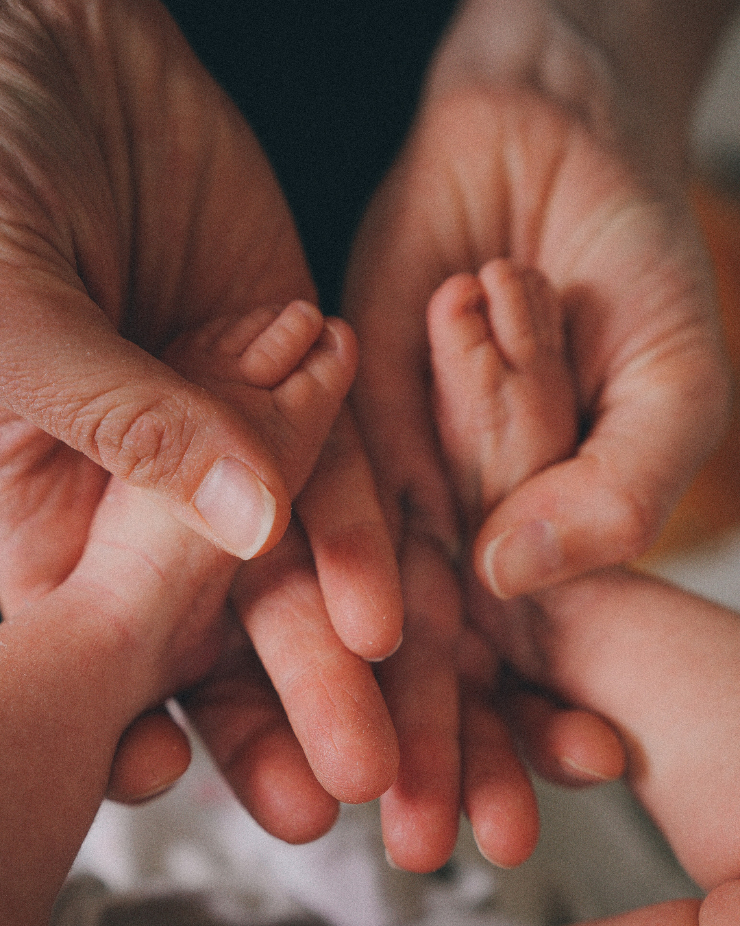 Sibling gently holding newborn baby during a natural family newborn photography session in Solihull