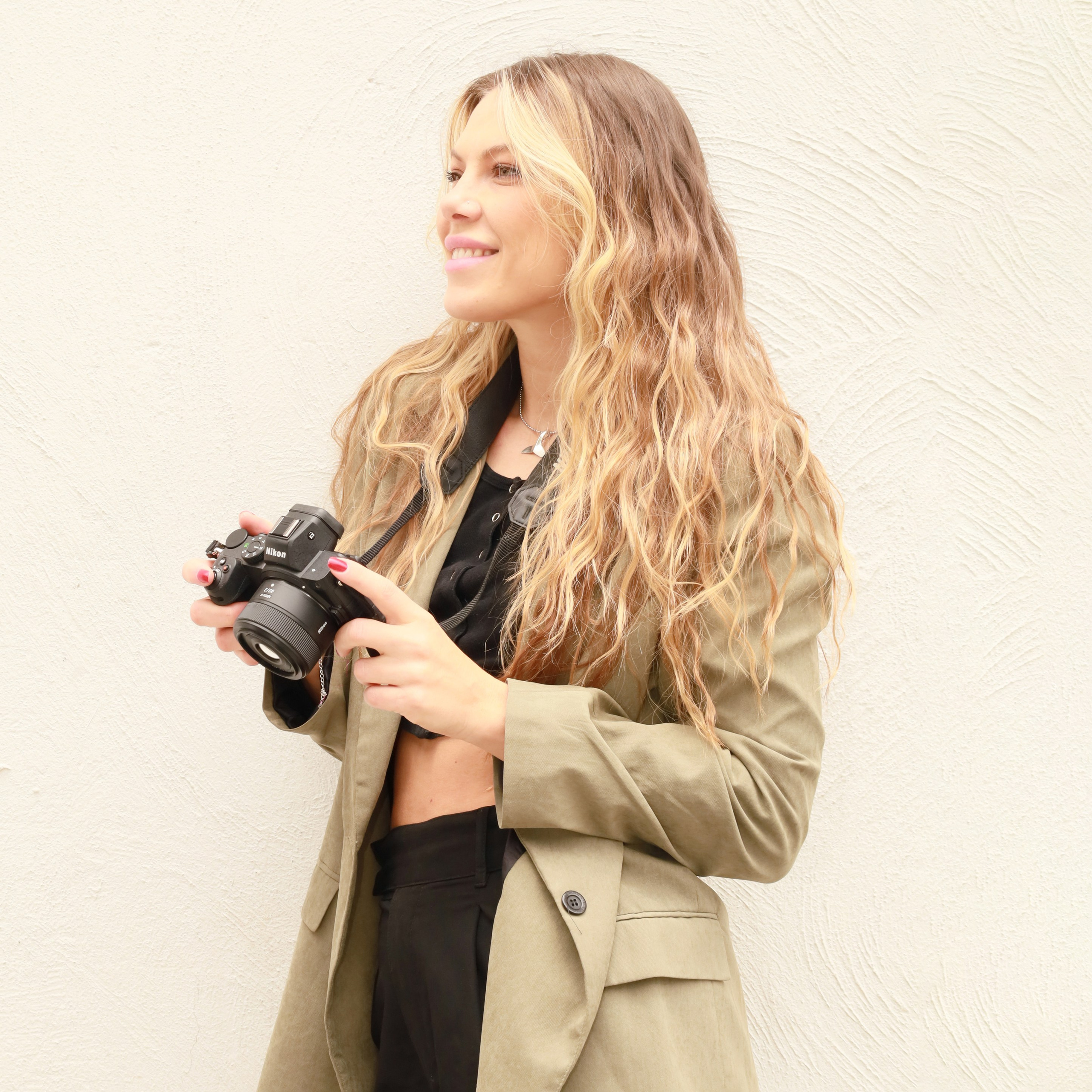 Dasha, apasionada fotógrafa, enfocada detrás de la lente en una sesión fotográfica profesional