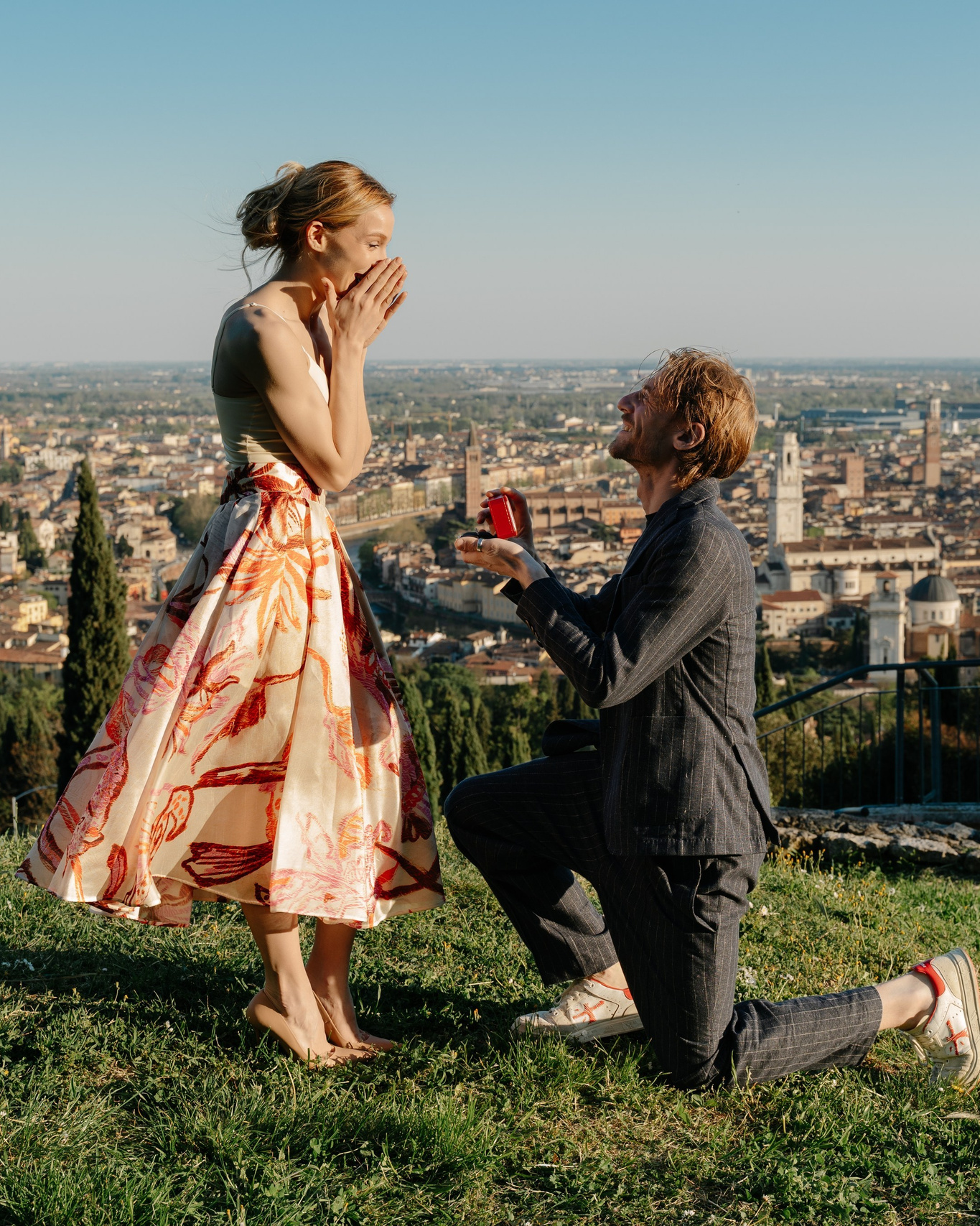 Marriage proposal in Verona with man kneeling at sunset overlooking the city of verona