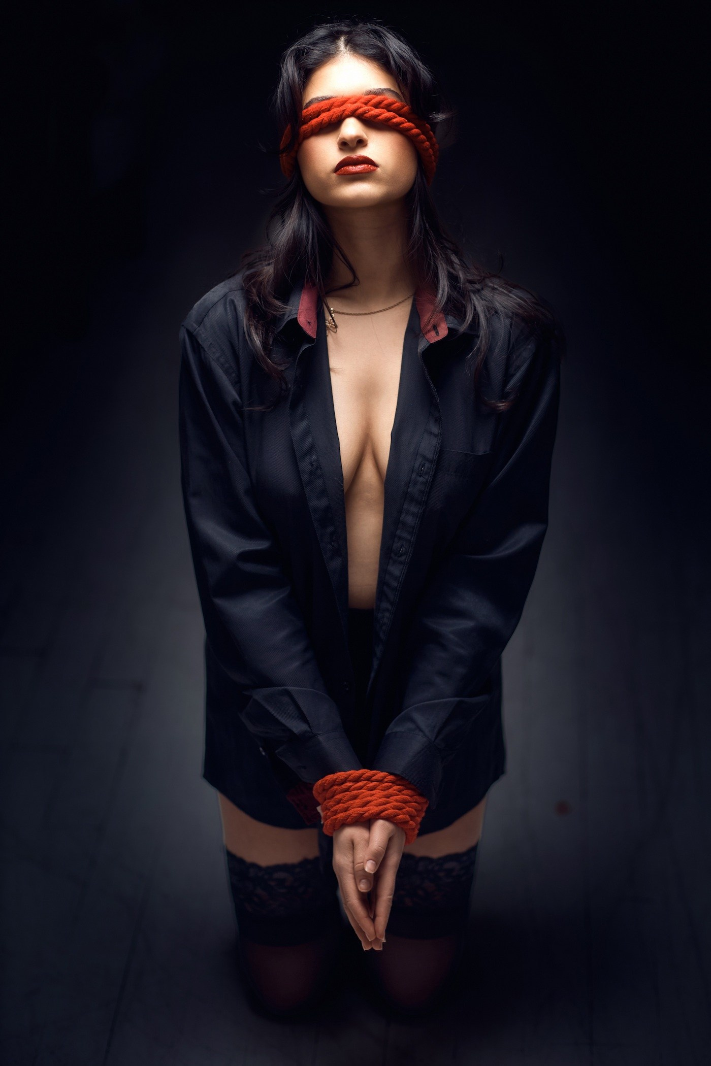 Fine art boudoir portrait of a woman kneeling with eyes covered
