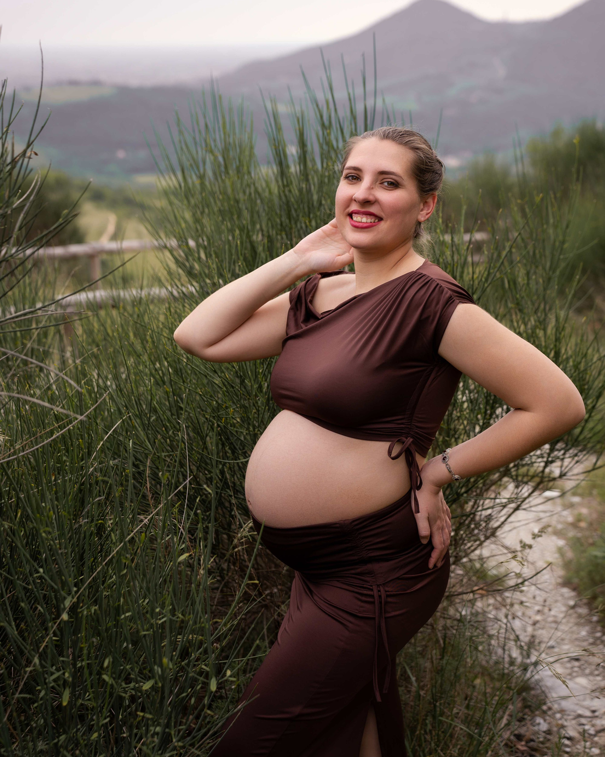 Futura mamma in abito elegante durante un servizio fotografico gravidanza all'aperto