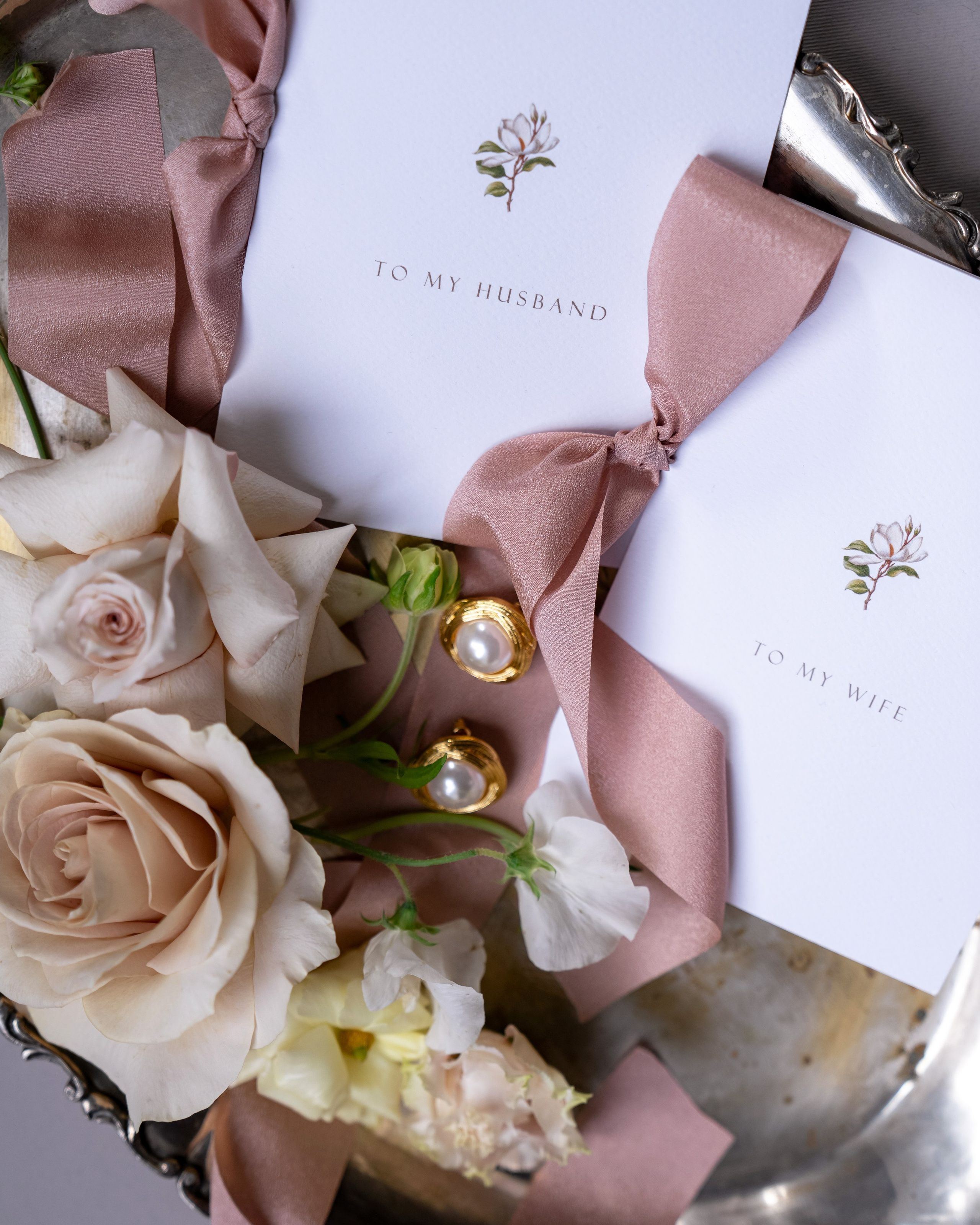 Flatlay of bridal accessories and invitation suite