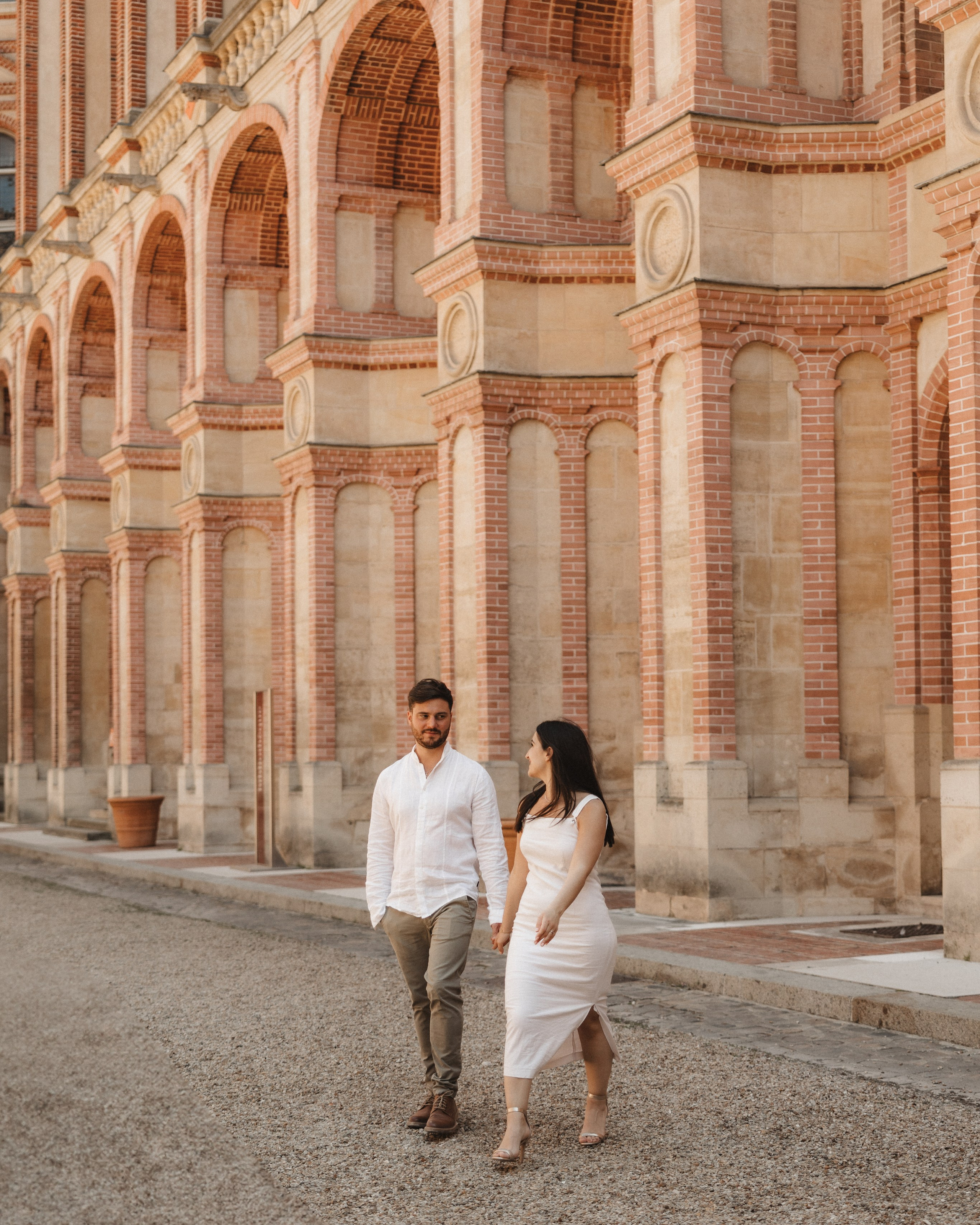 Casal a passear junto a arquitetura histórica no Museu de Arqueologia Nacional do Castelo de Saint-Germain-en-Laye, em França