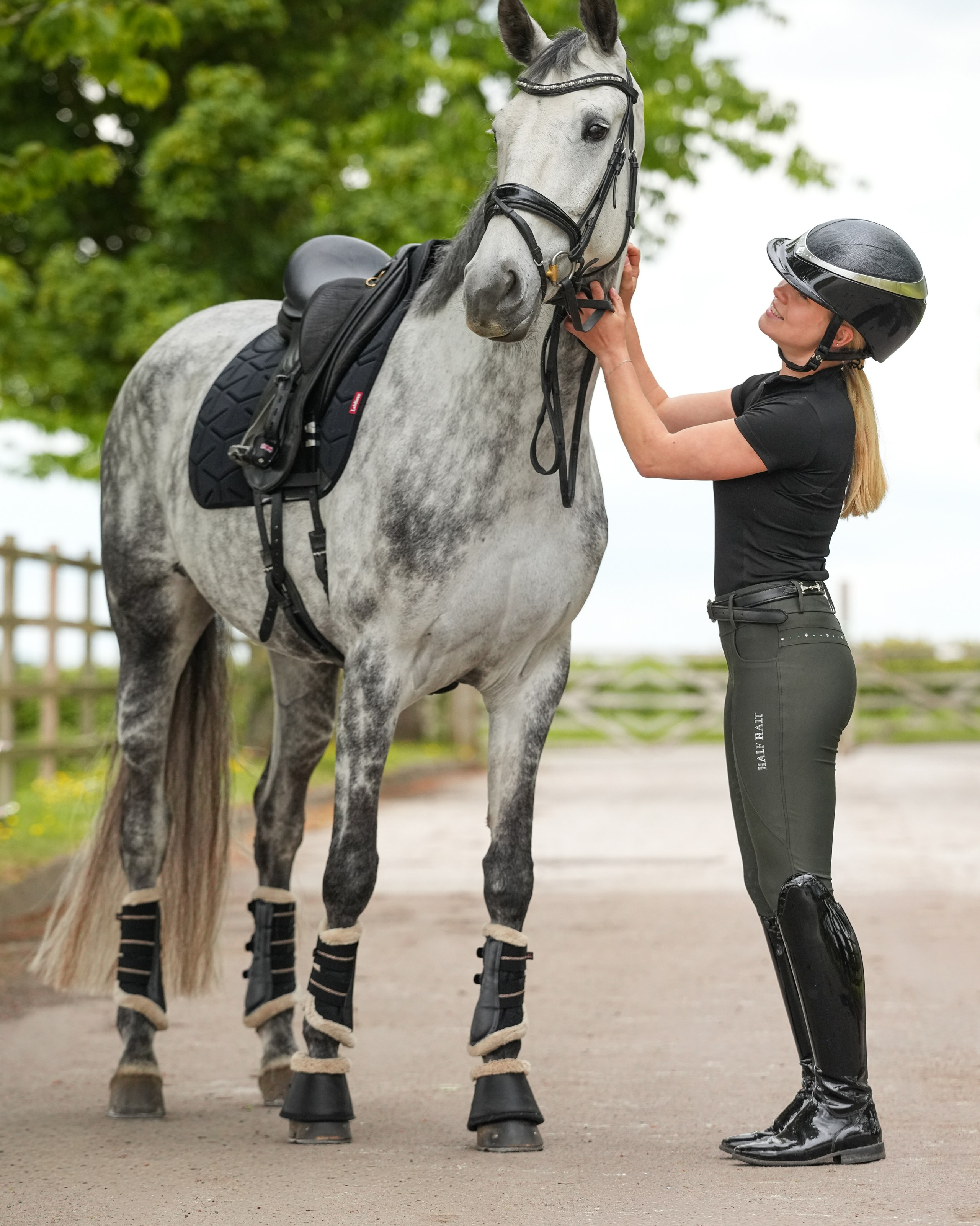 Teen girl holding horse’s halter during soft evening light equestrian portrait