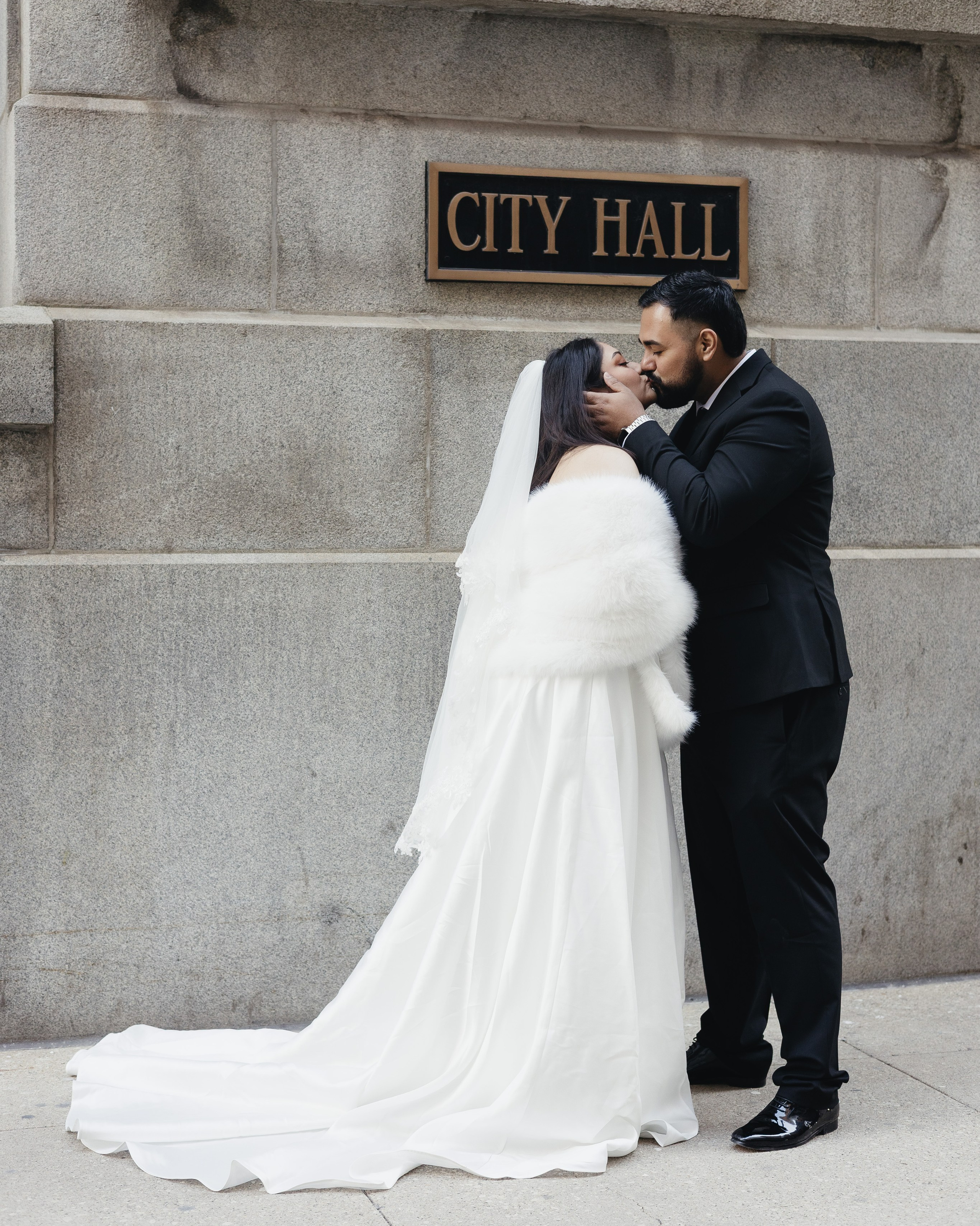 Couple standing in front of Chicago City Hall with City Hall sign visible in the background.