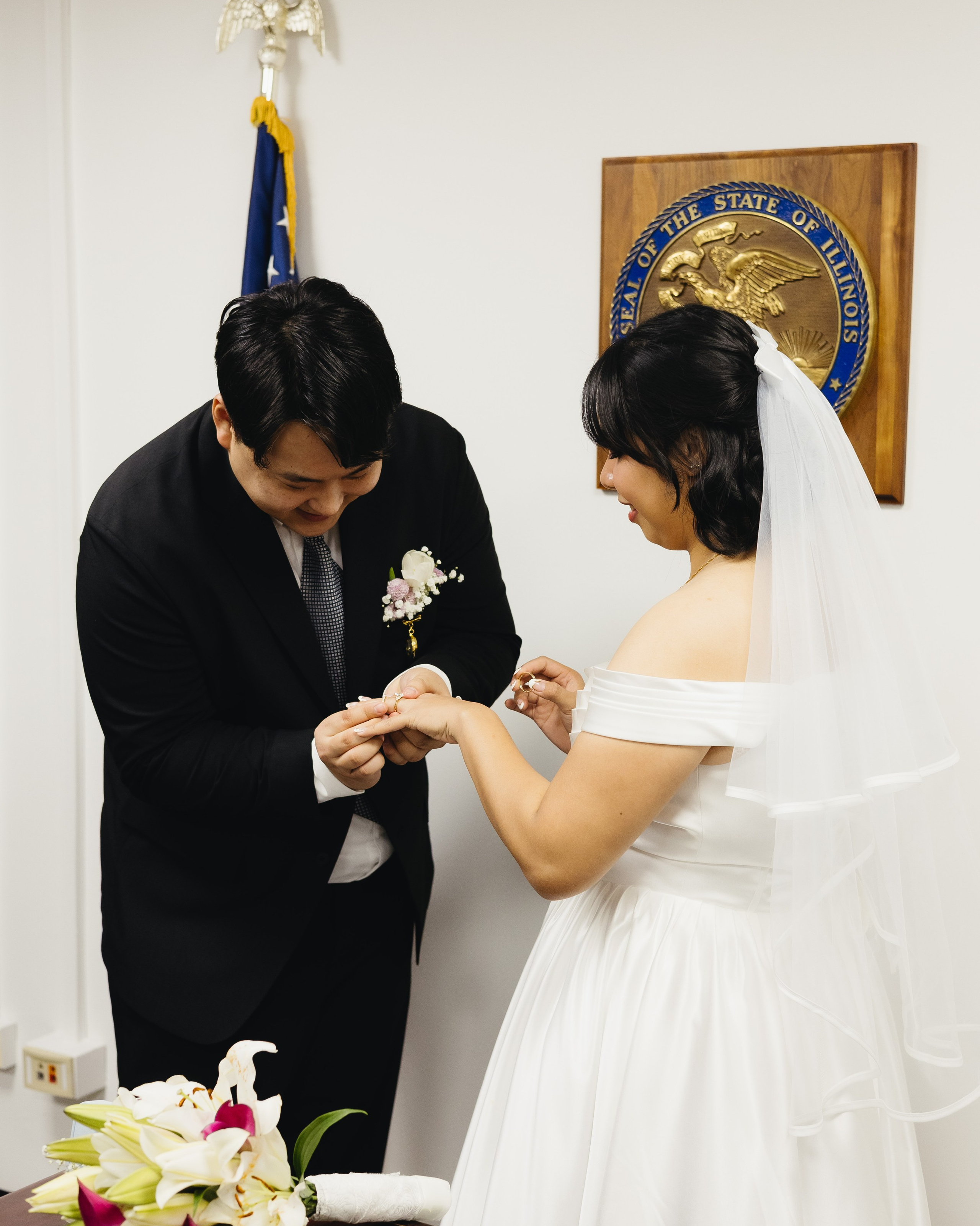 Groom placing a ring on the bride’s finger during a City Hall wedding ceremony