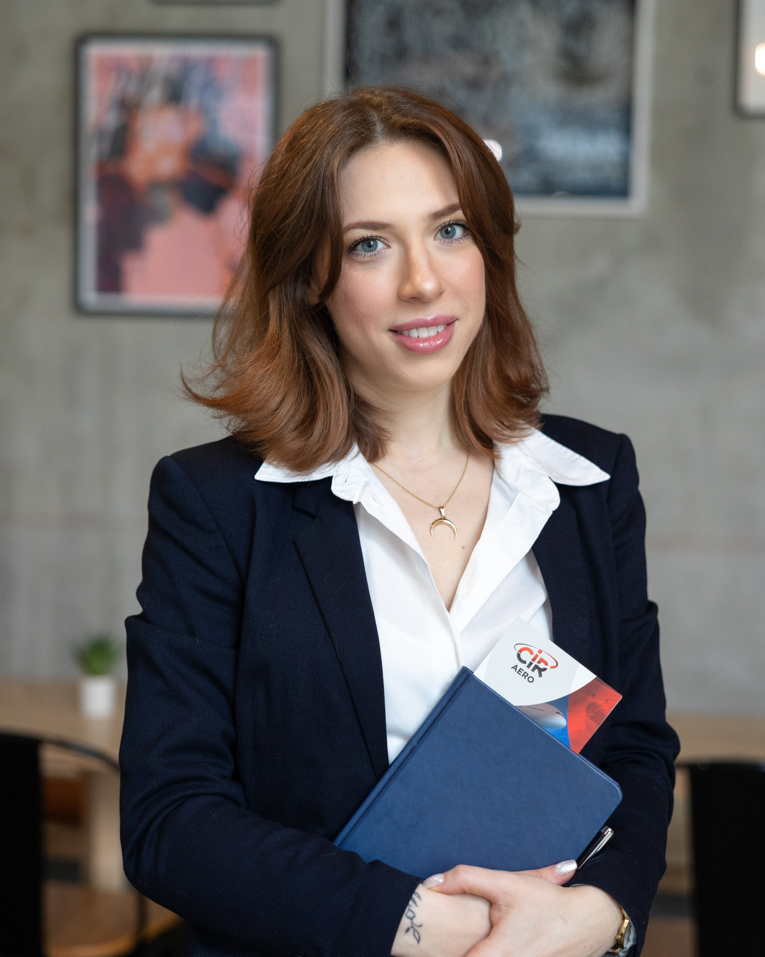 Professional portrait of a businesswoman holding a folder