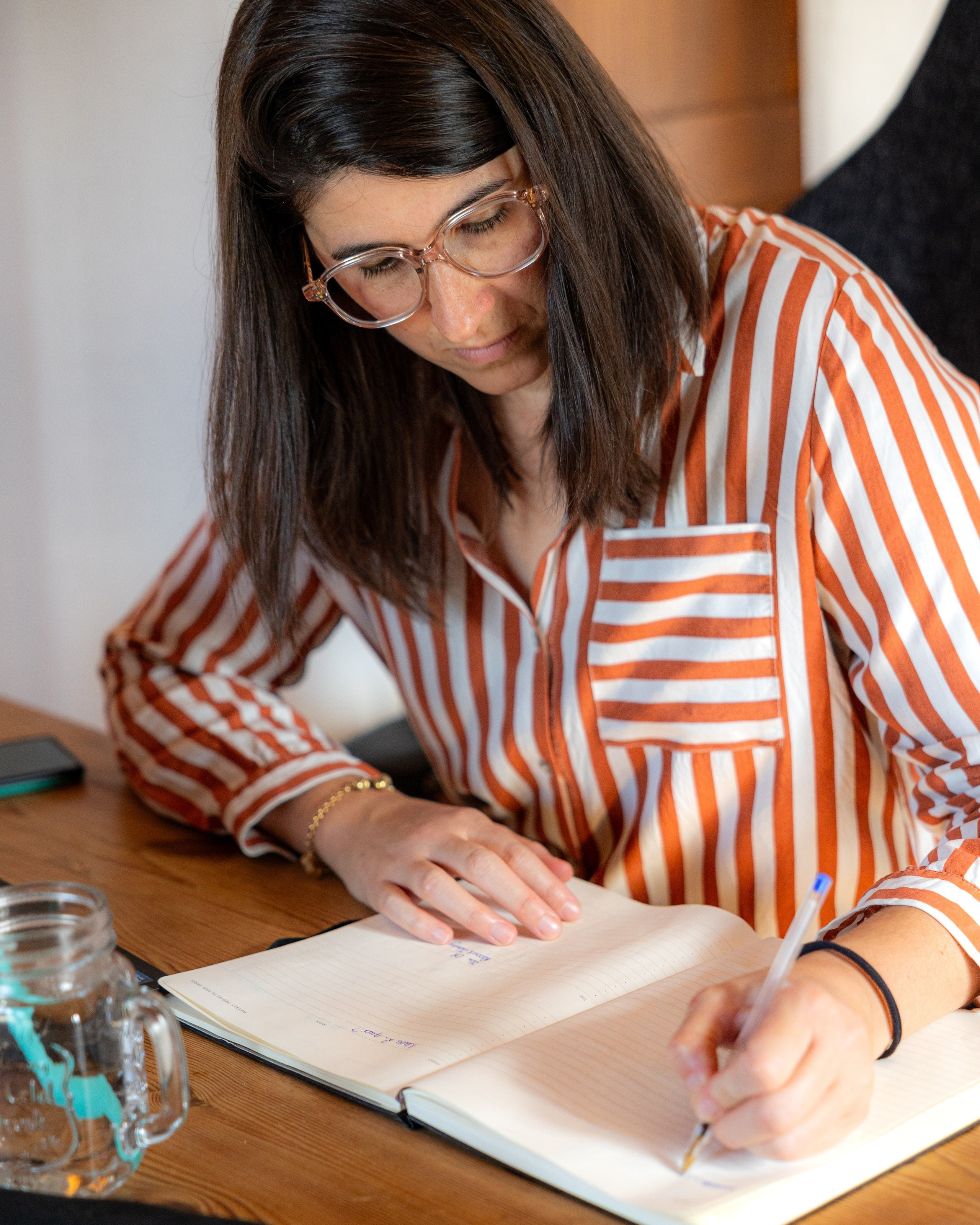 Woman writing in a notebook during a personal brand photography session