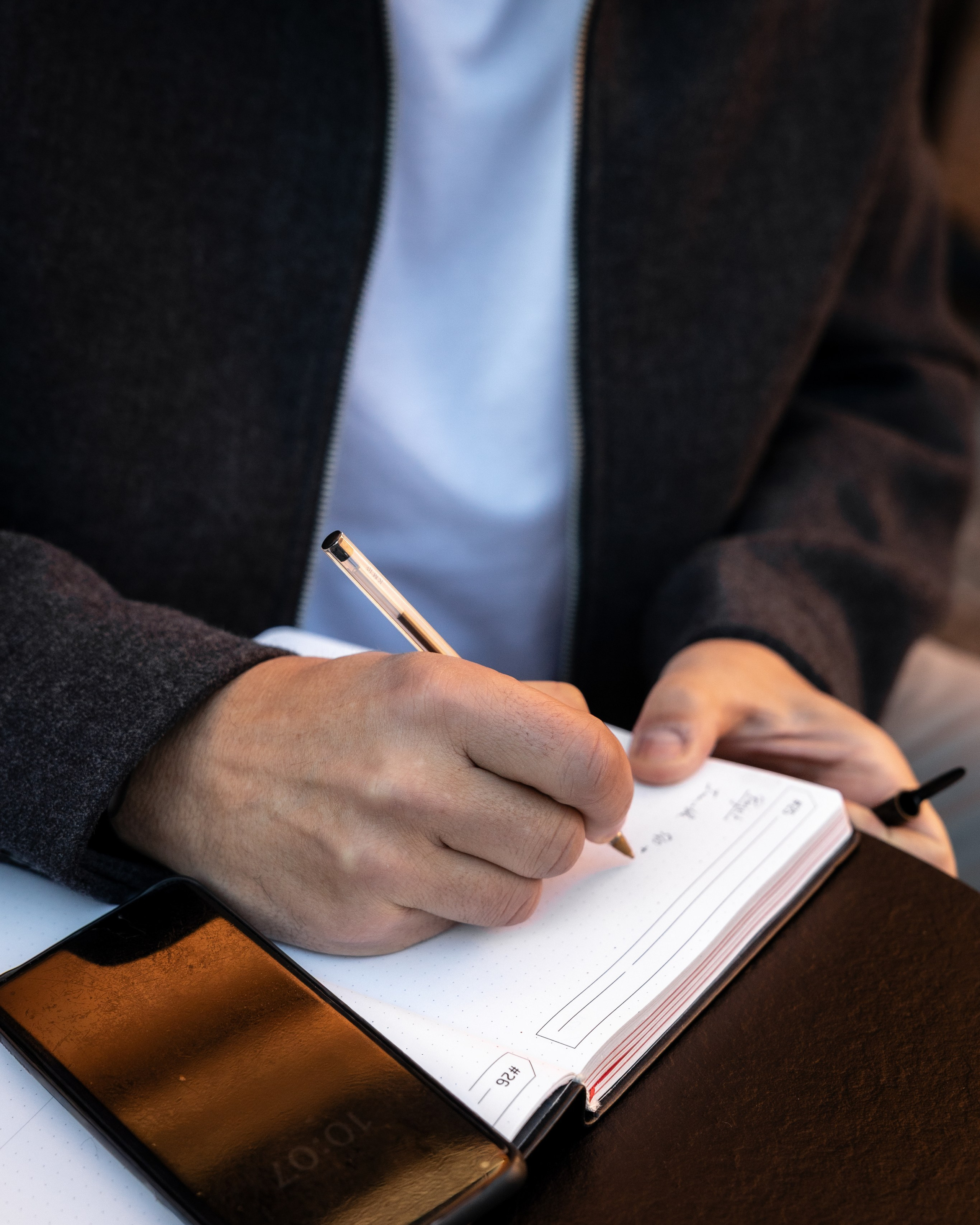 close-up of a professional writing in a notebook during a corporate branding photo session