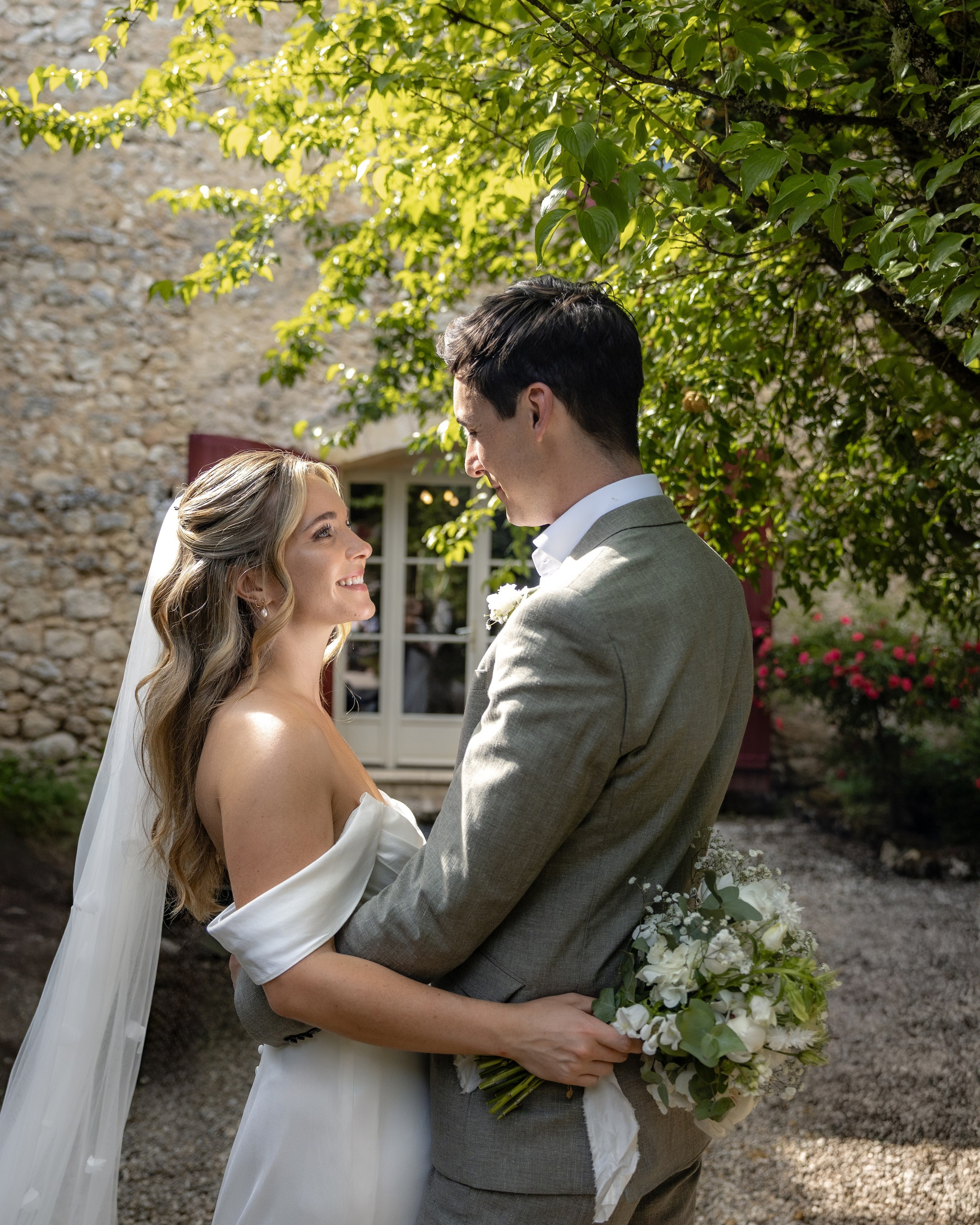Bride and groom embracing in soft afternoon light at Château Sentout during their destination wedding in France.