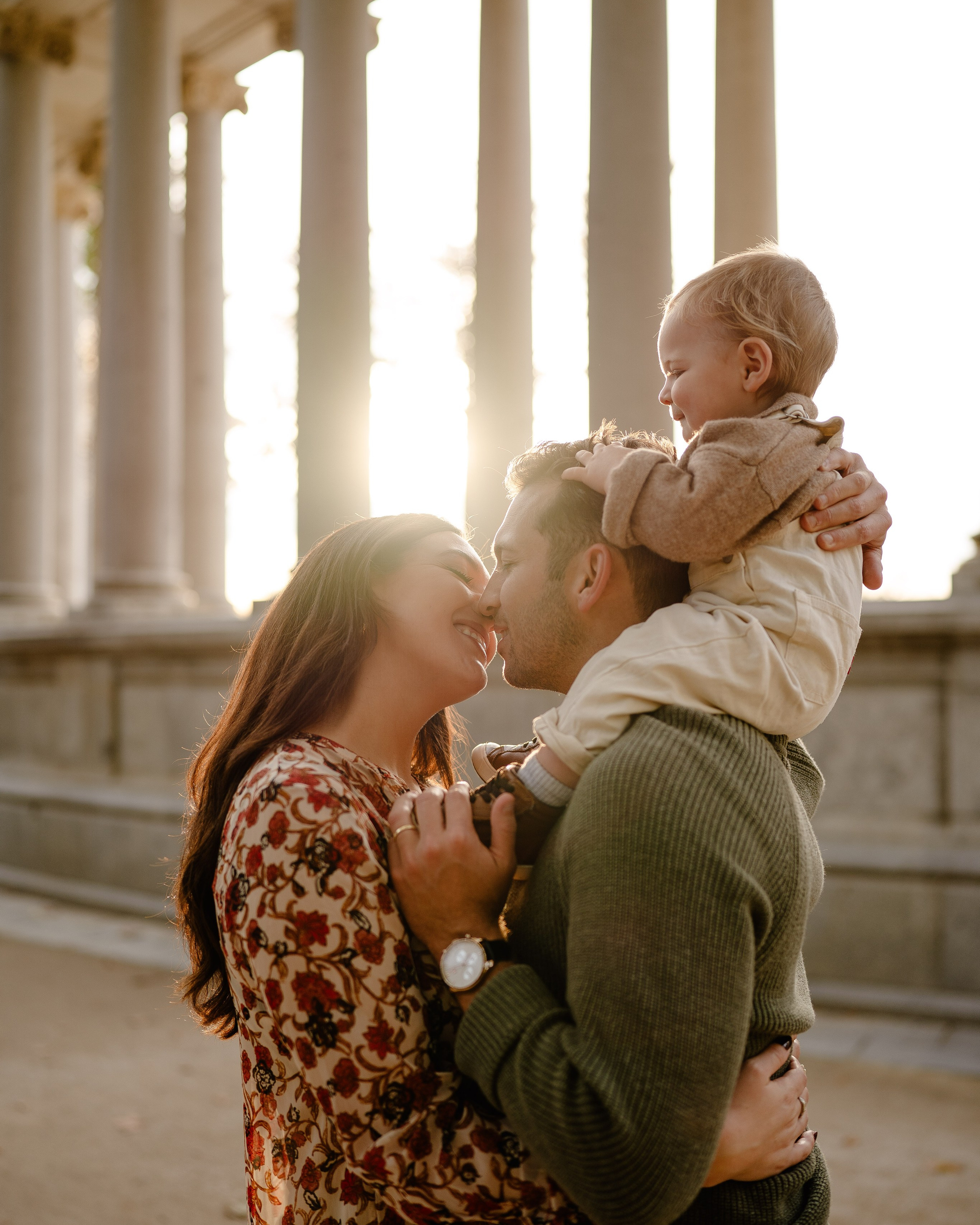 Couple with baby in Retiro Park, Madrid at sunset.