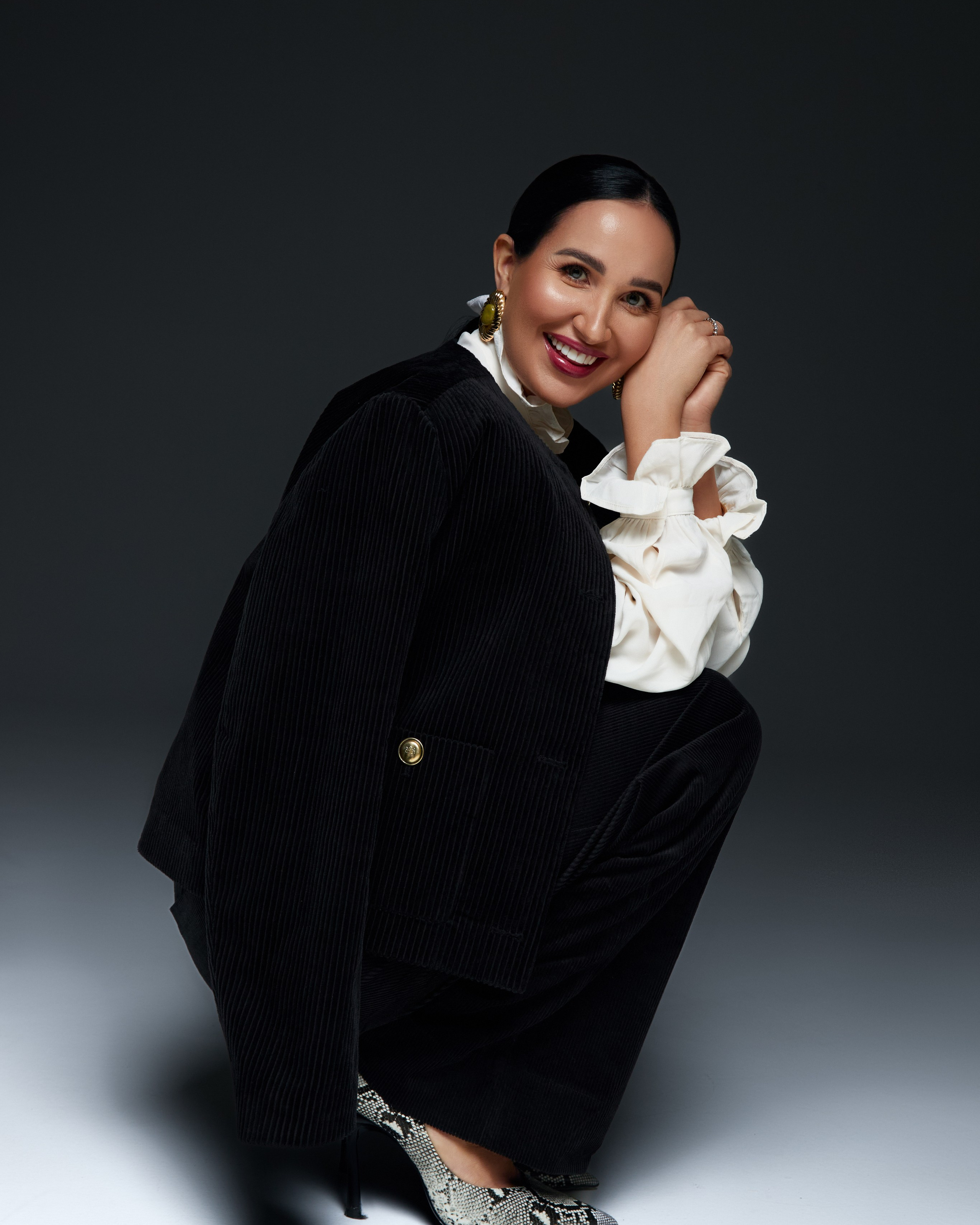 Fashion photographer Hanna Asaulova | Stylish model in a pink top and wide jeans in a relaxed pose on a white background, fashion photoshoot in Vilnius.