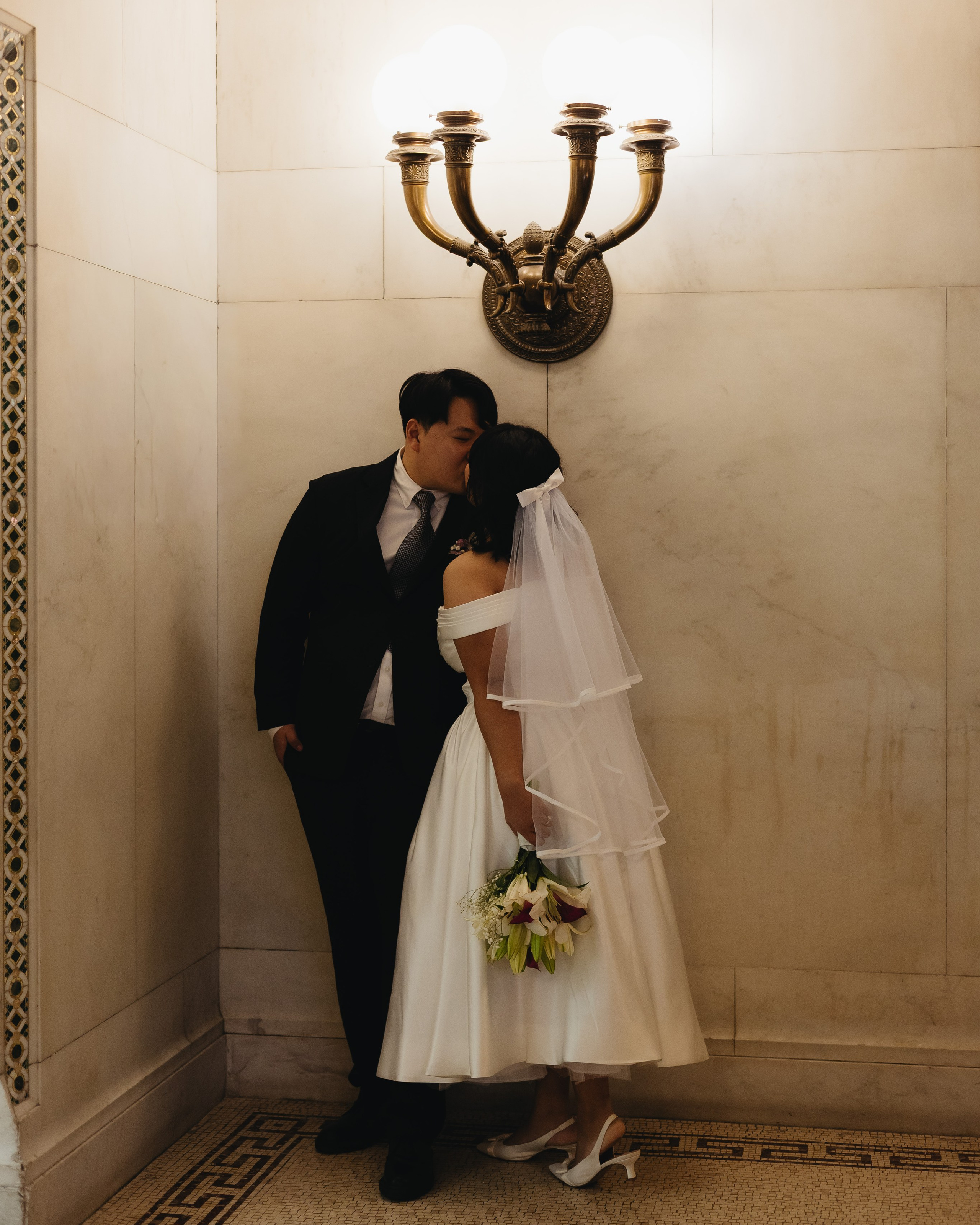 Couple standing under a lamp inside the Chicago Cultural Center