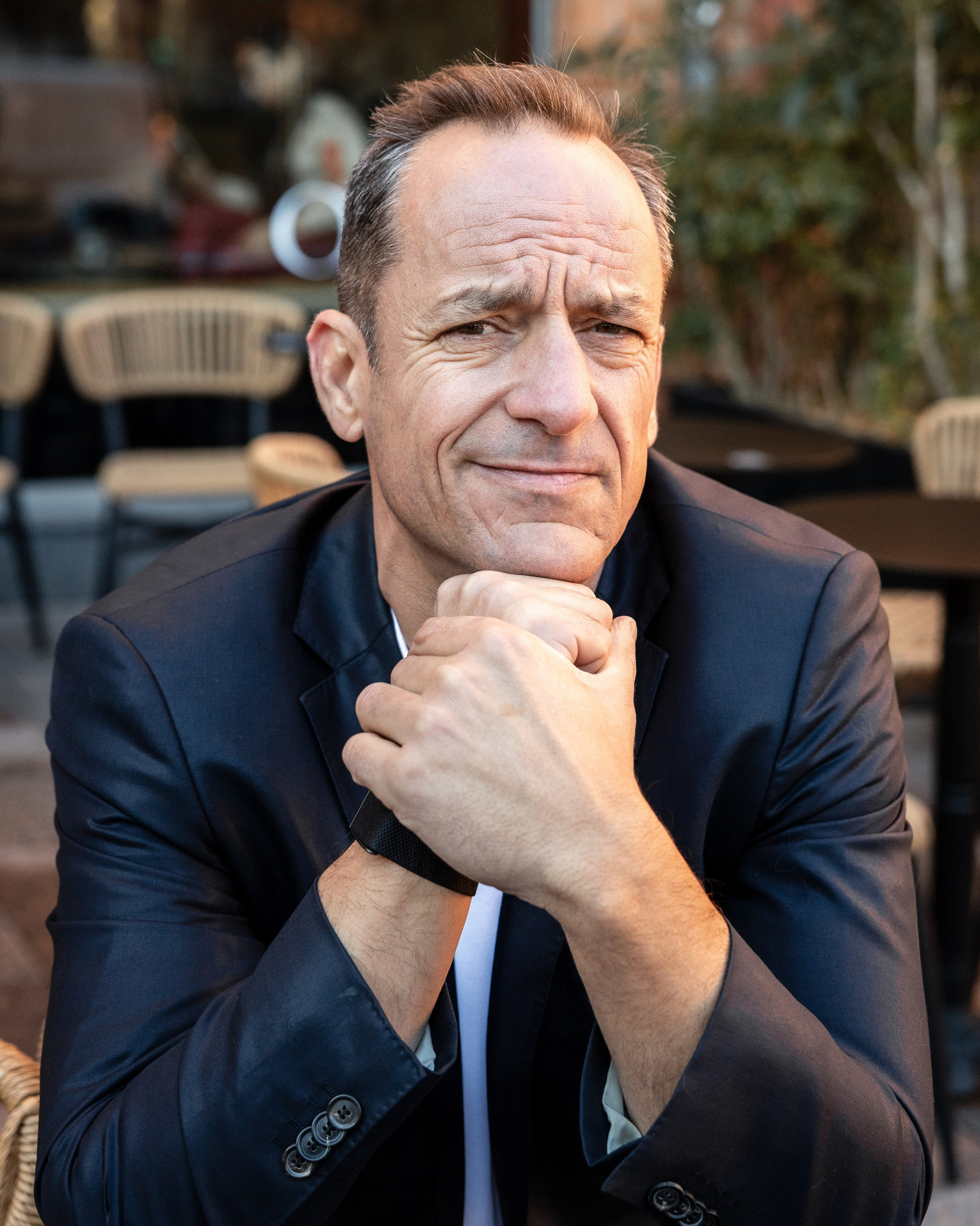 professional portrait of a businessman sitting at a café terrace during a corporate photography session in France