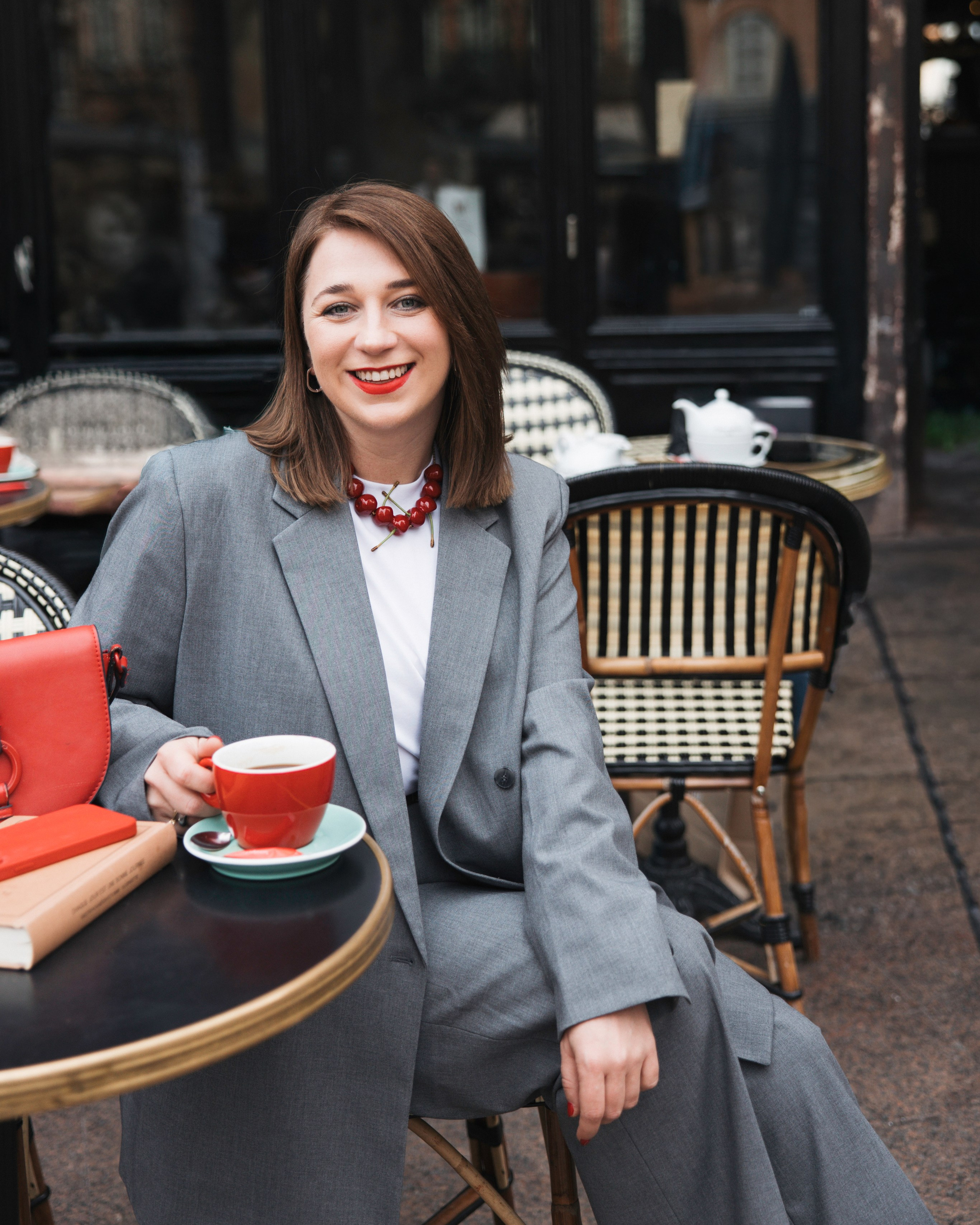 Woman in grey blazer and red shoes at a café terrace with cappuccino, Toulouse personal brand portrait