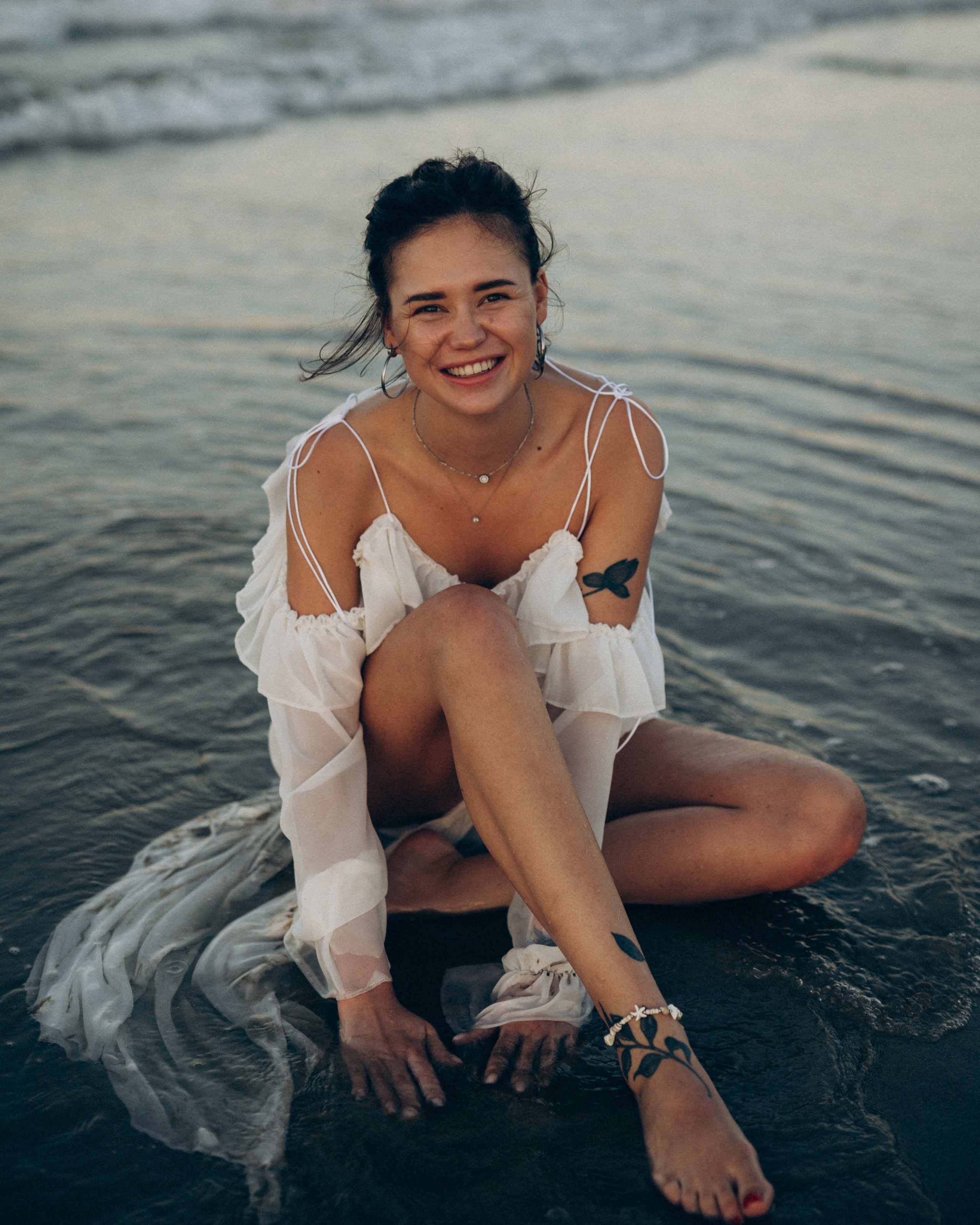 Woman sitting by the sea during a natural photoshoot in Rimini, Italy.