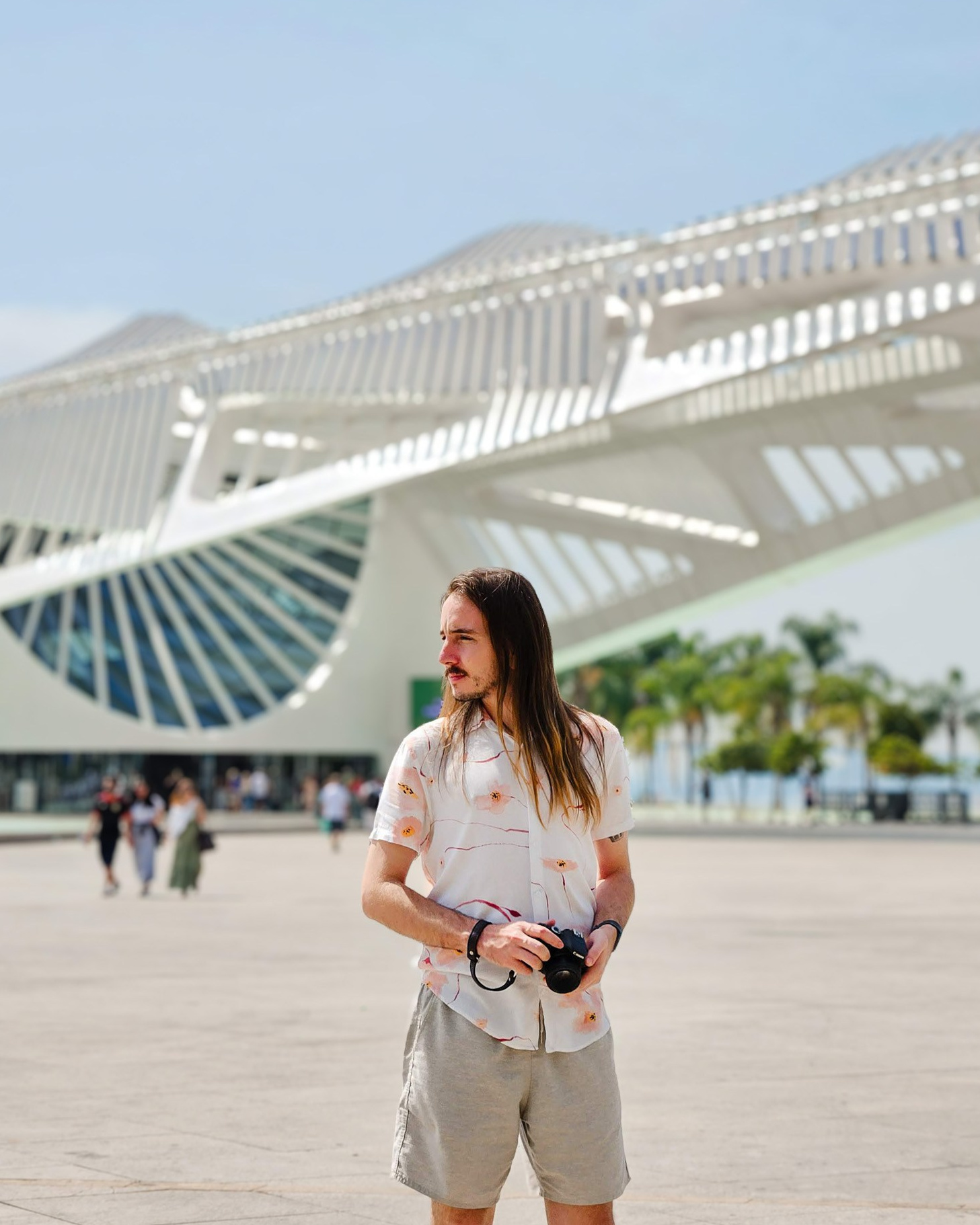 Fotógrafo com a câmera na mão em frente ao museu do amanhã.