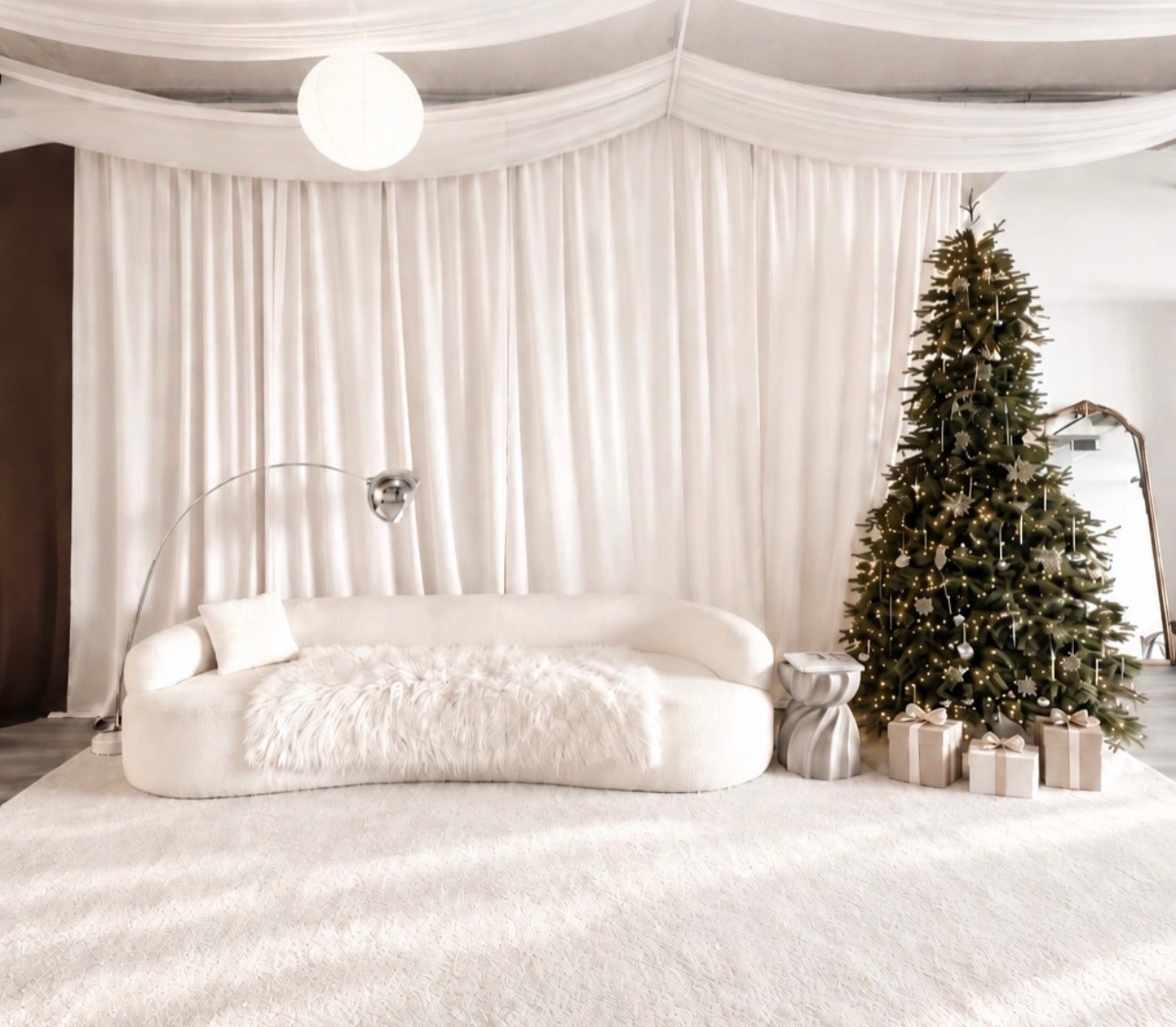Bright neutral Christmas studio setup with a tree and soft holiday décor