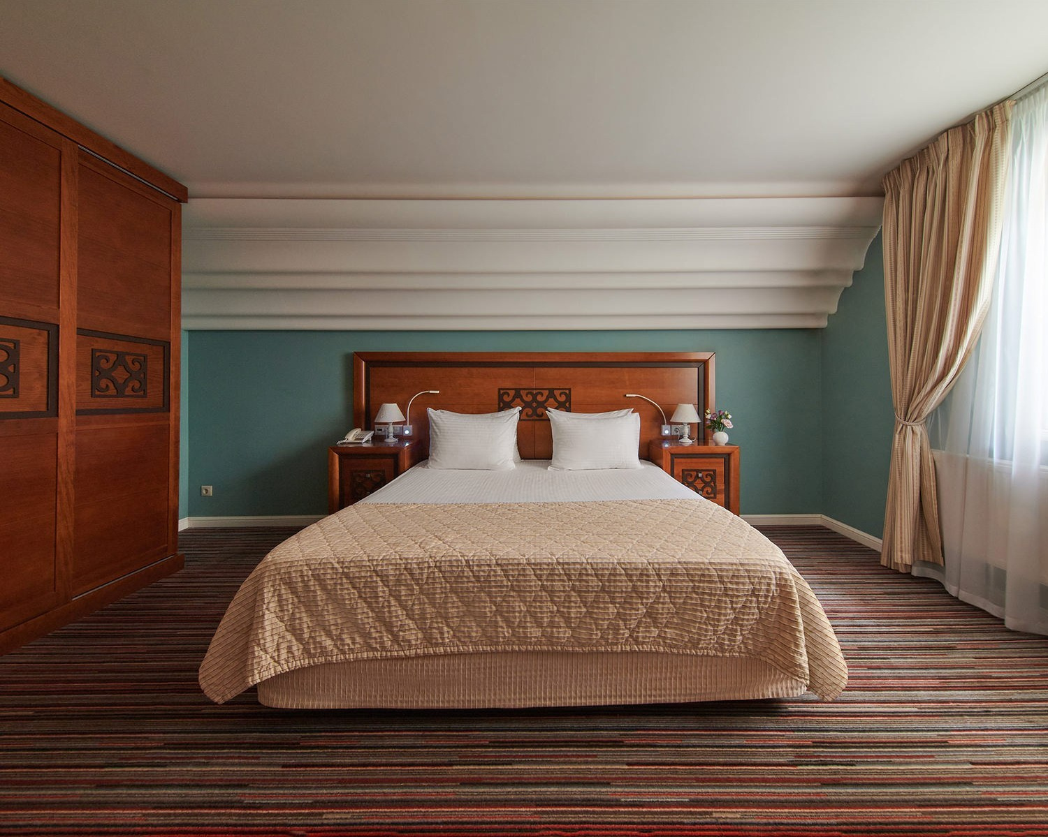 Hotelfotografie Wien – Elegantes Schlafzimmer mit großem Bett und Tageslicht.