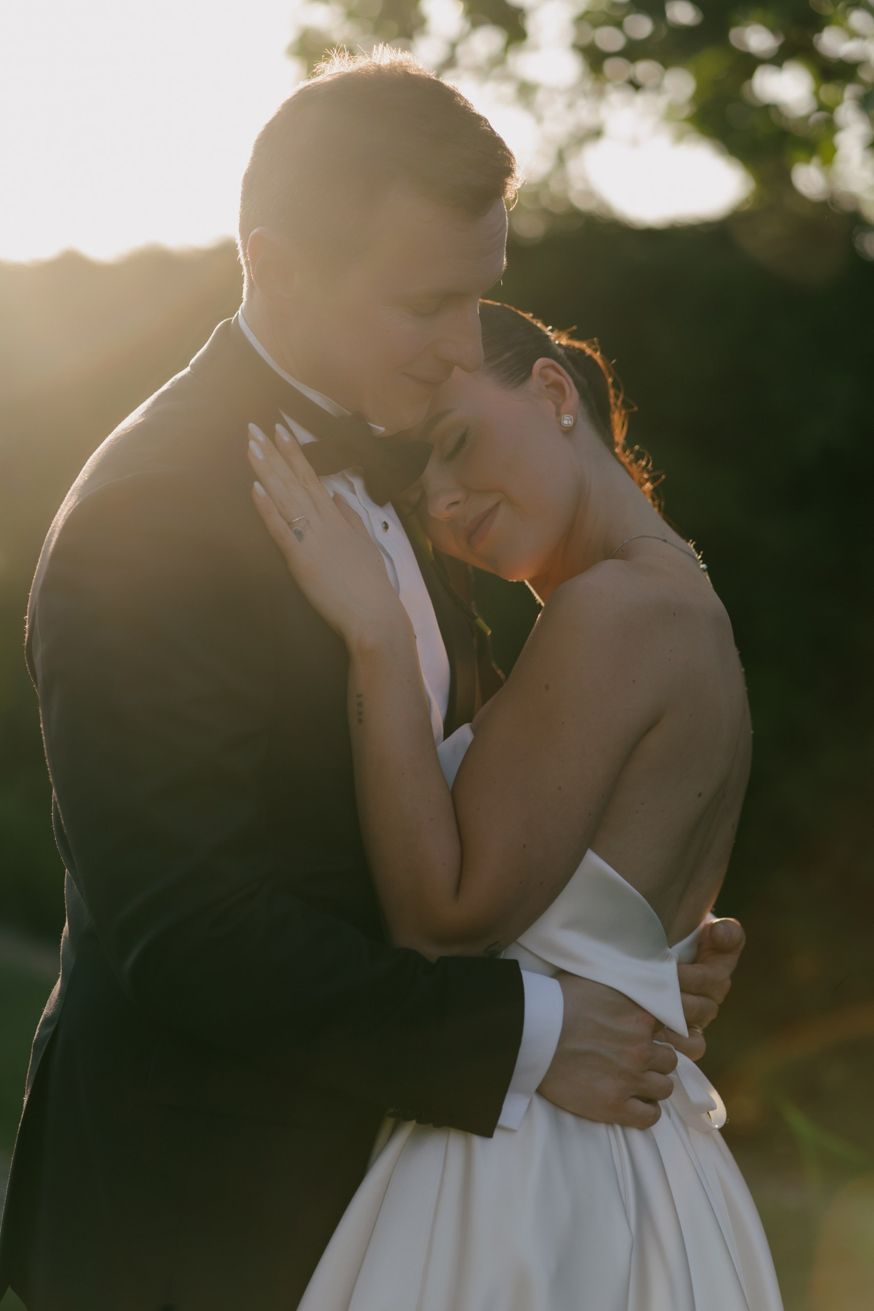 Romantic close-up wedding portrait of couple in soft golden hour light