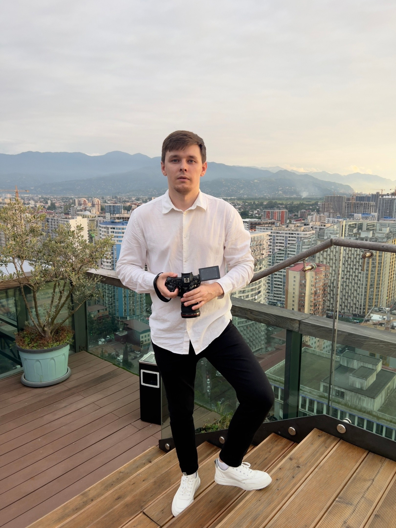 Свадебный видеограф стоит на Берегу Батуми и его фотографирует свадебный видеограф в Тбилиси такая вот Грузия