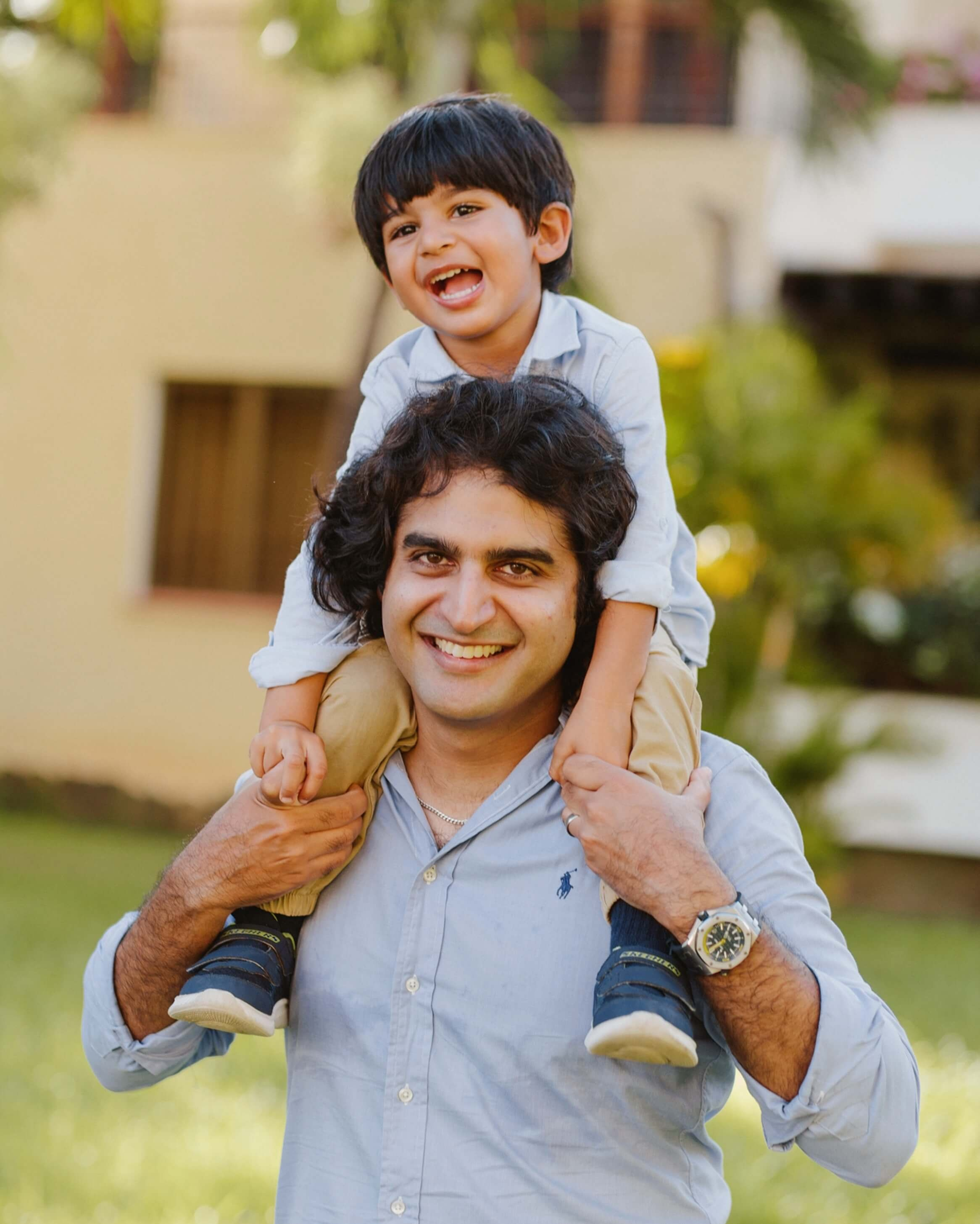 A cheerful father tossing his child into the air during a family shoot in Mombasa, Kenya—candid photography full of energy and love.