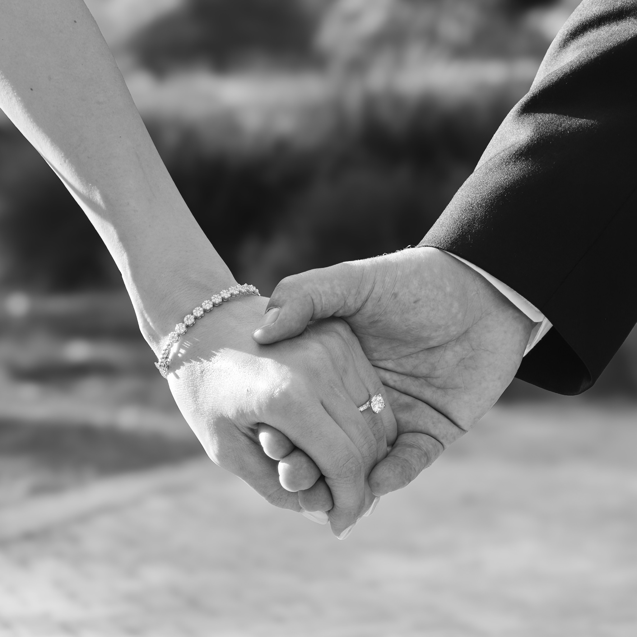 Groom holding bride's hand showing engagement ring in Chicago wedding session