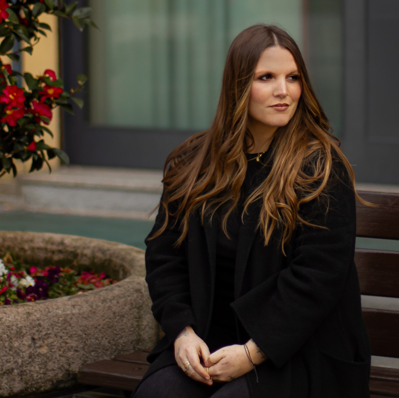 Женщина сидит на деревянной скамейке на исторической улице. Фотограф Милан портрет лавстайл.