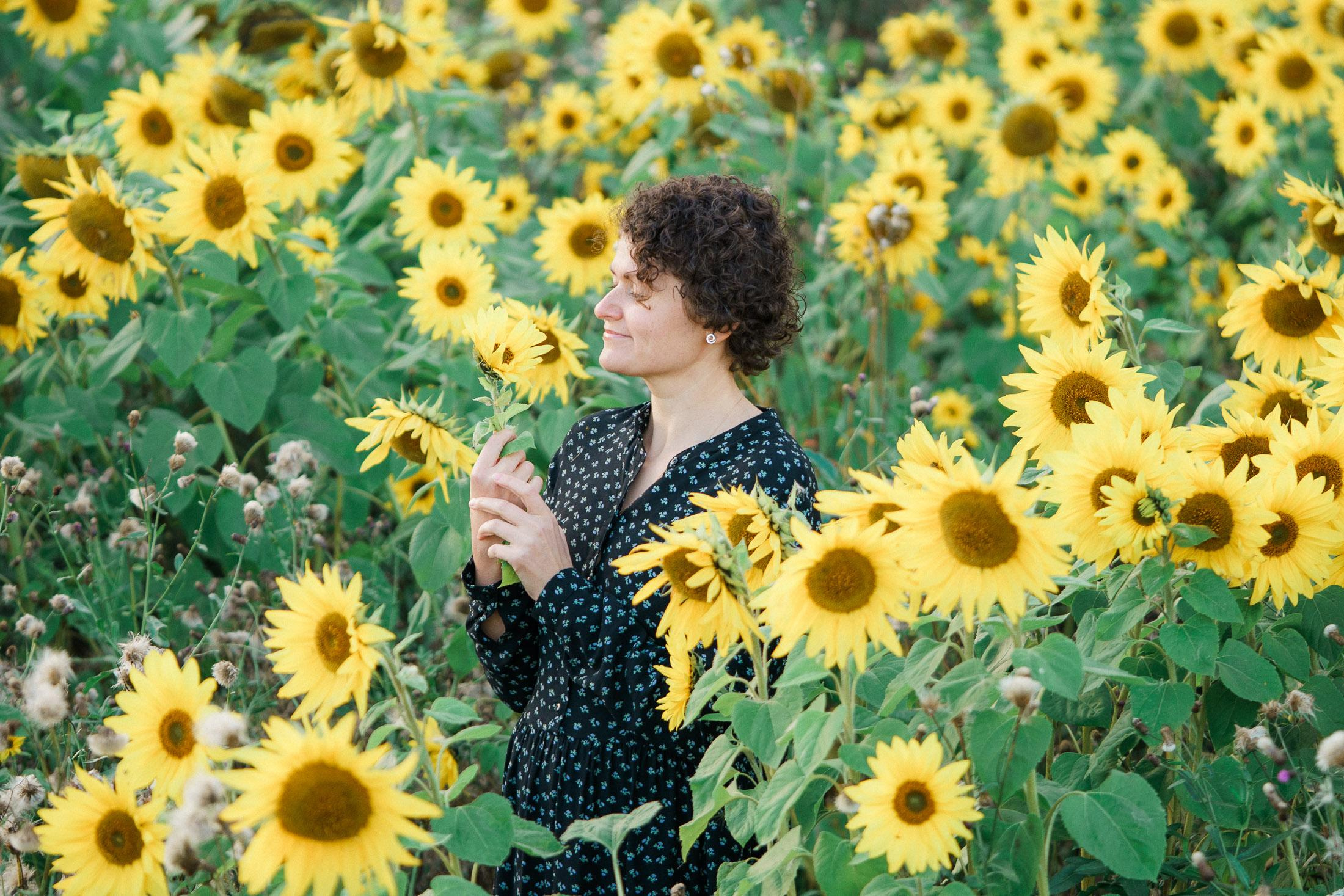 muotokuva naisesta auringonkukkapellolla