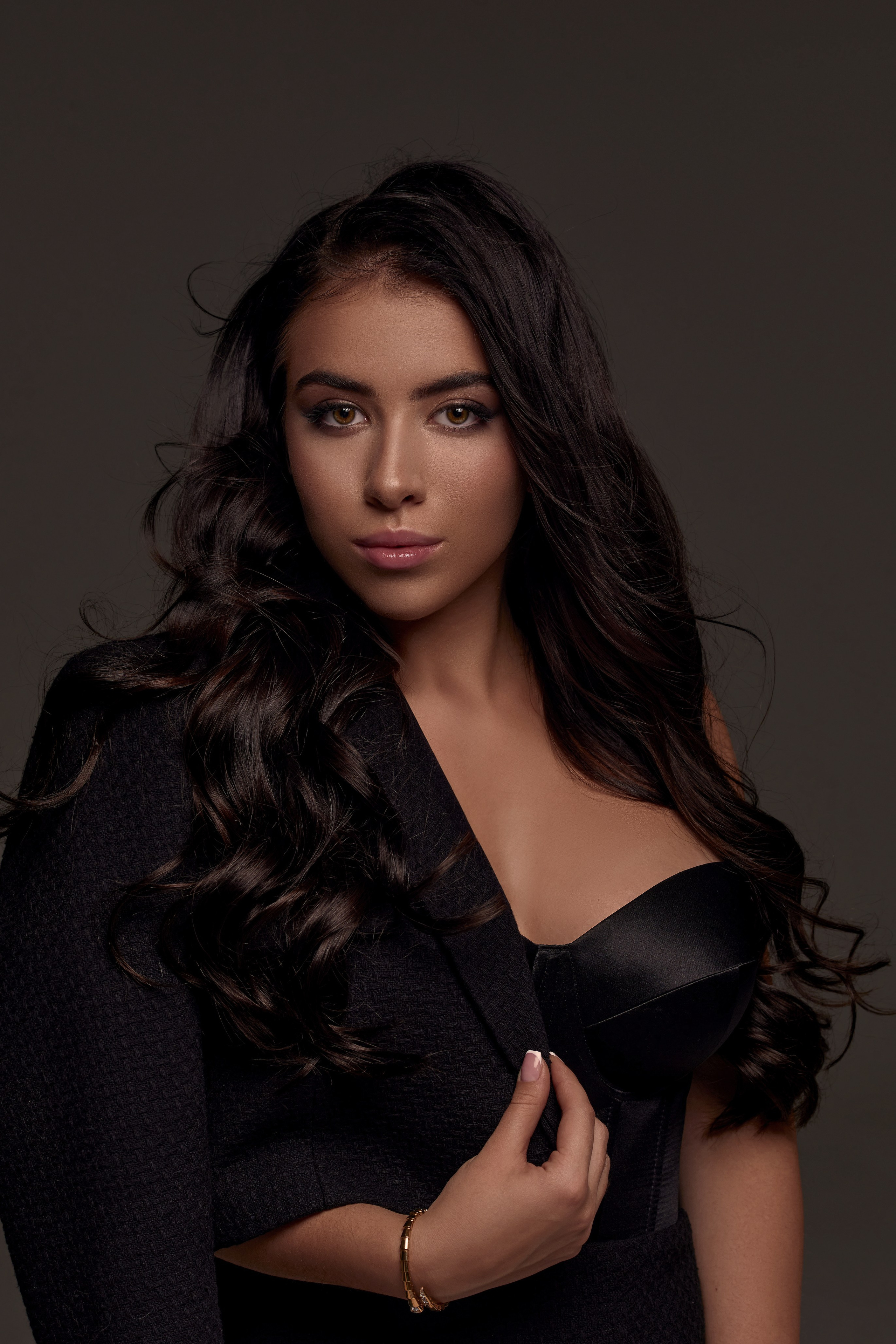 Sesja zdjęciowa dla kobiet – brunetka w czarnej sukience, zmysłowy portret, profesjonalne zdjęcie.