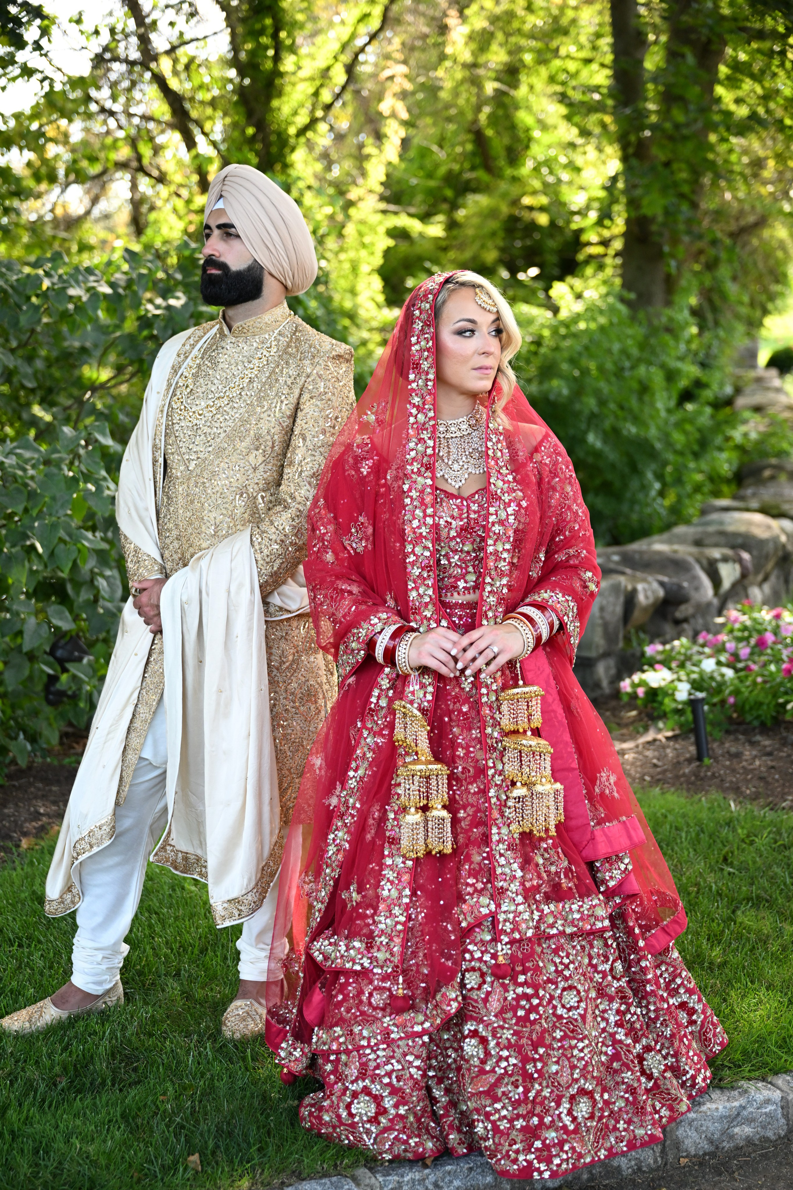 a man and woman in traditional clothing walking through a garden