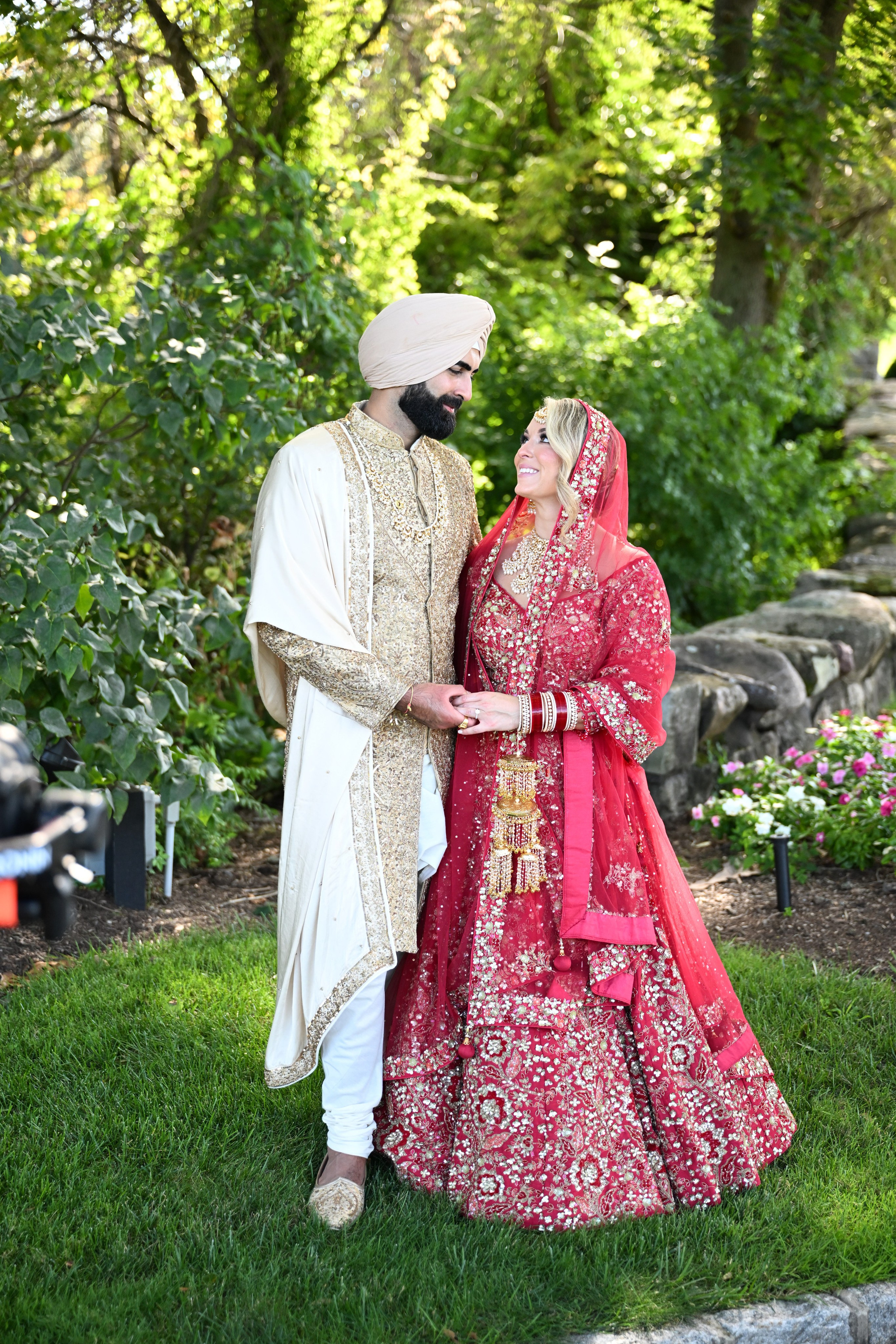 a bride and groom pose for a photo in the garden