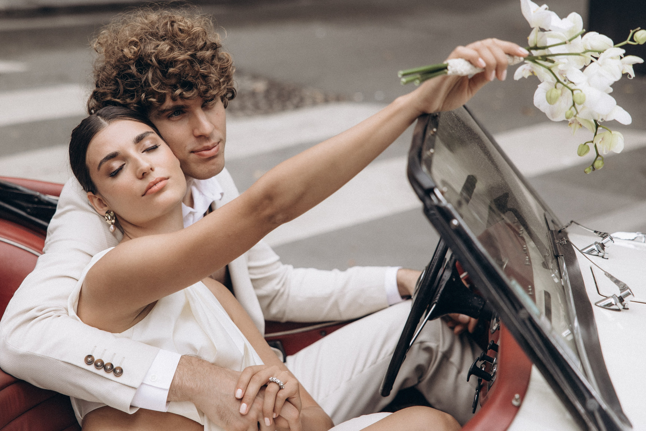 Editorial-style groom and bride portrait in soft light in convertible