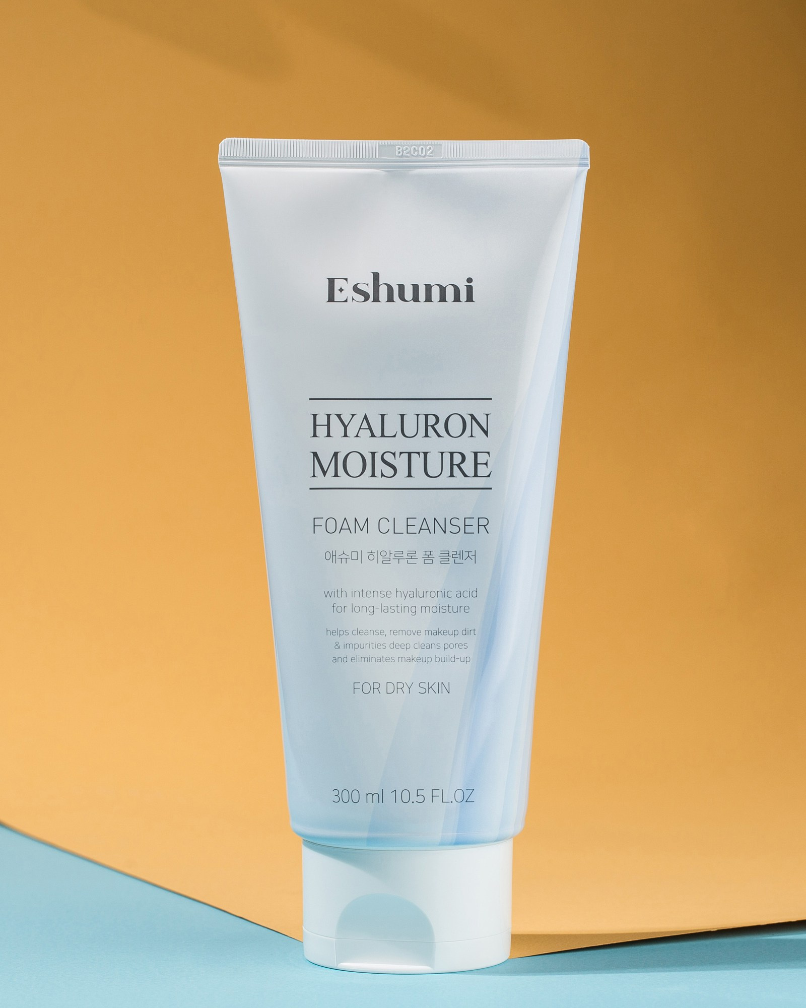 Açıq mavi rəngli, ağ qapaqlı Eshumi Hyaluron Moisture Köpük Təmizləyici. Məhsulun qabının üzərində "Hyaluron Moisture Foam Cleanser" yazısı və 300 ml həcmi oxunur.