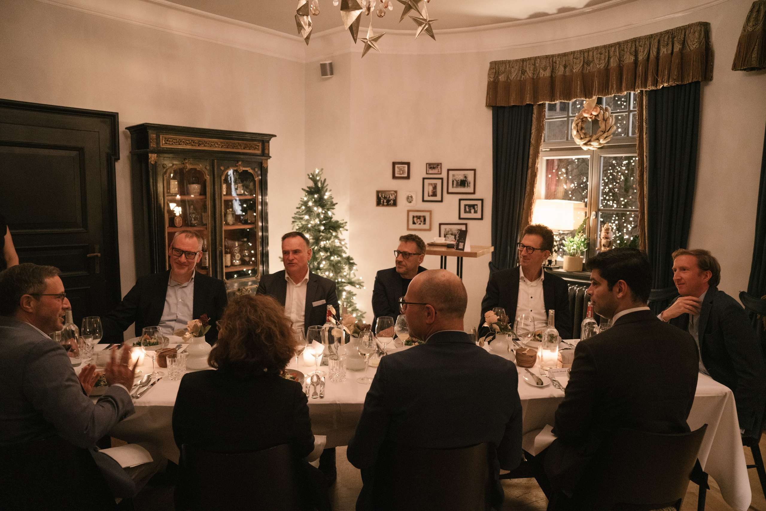 A business group seated around a dinner table at an festive holiday event