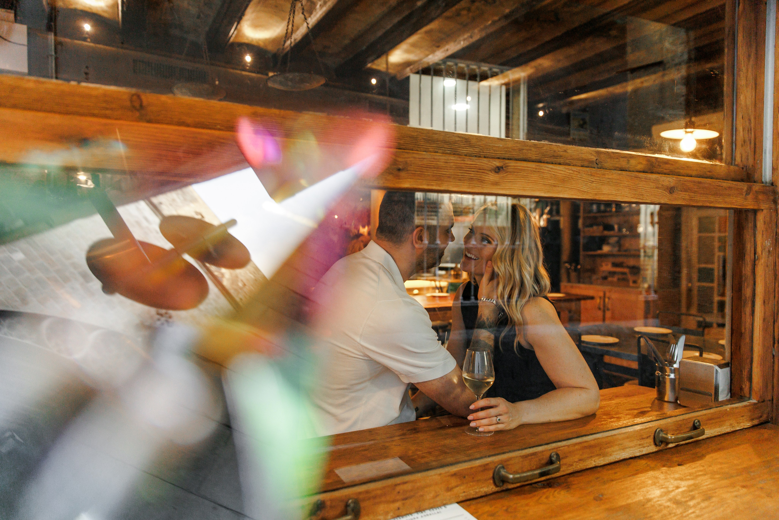 A couple enjoying their drinks during their romantic engagement photoshoot in Barcelona 