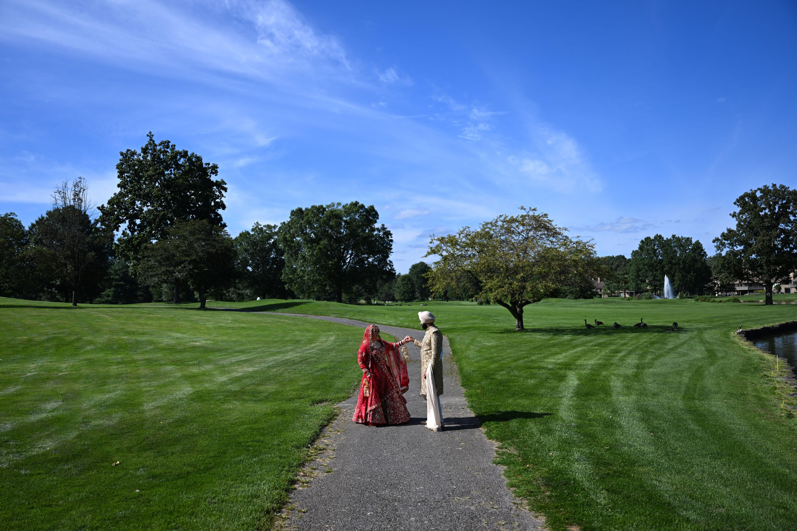 a couple walking down a path in a park