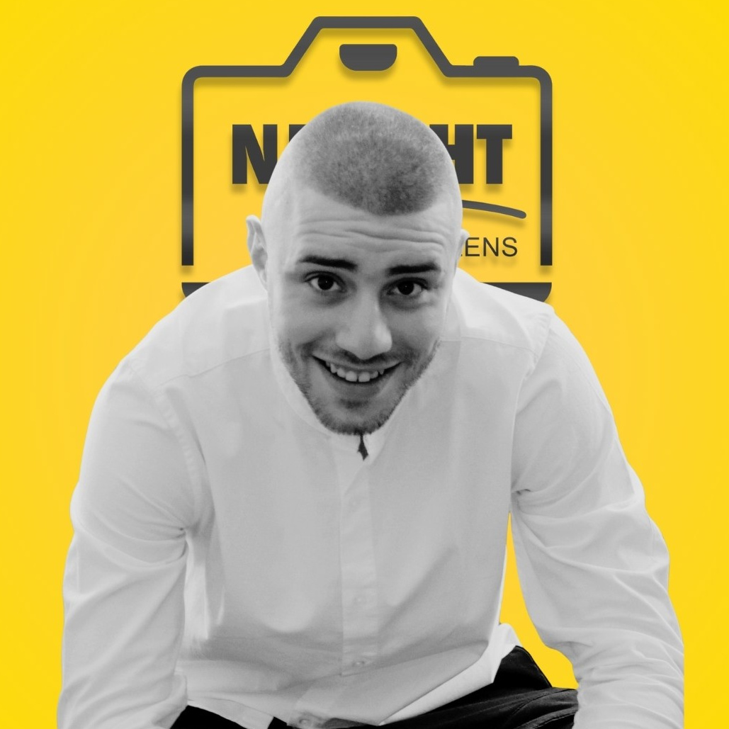 Portret profesional al unui bărbat pe fundal galben cu logo, expresie zâmbitoare