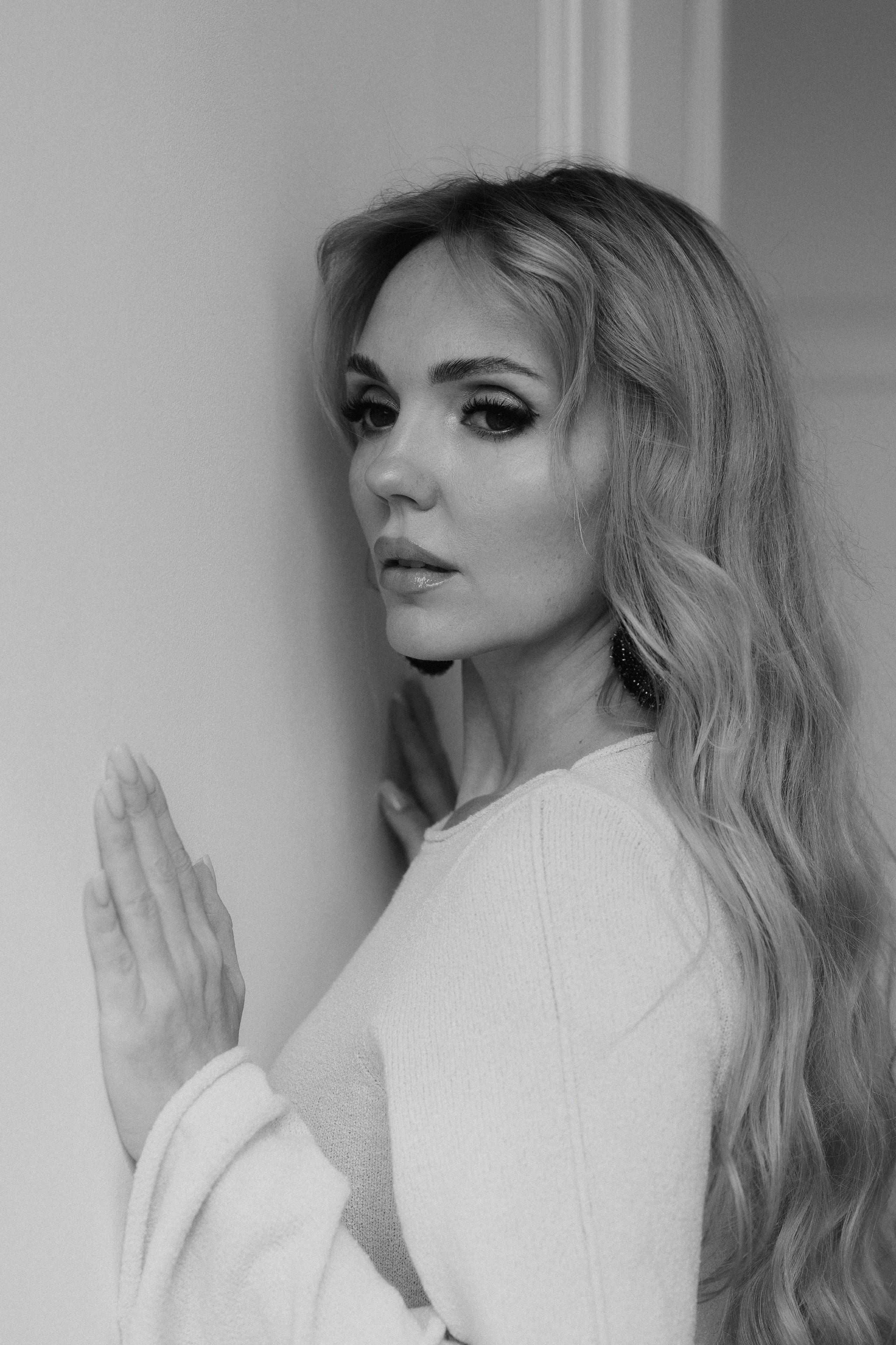 Close black and white portrait of a woman with long blonde hair, soft shadows and timeless feminine styling. Крупный чёрно-белый портрет девушки с длинными светлыми волосами и мягким светом.