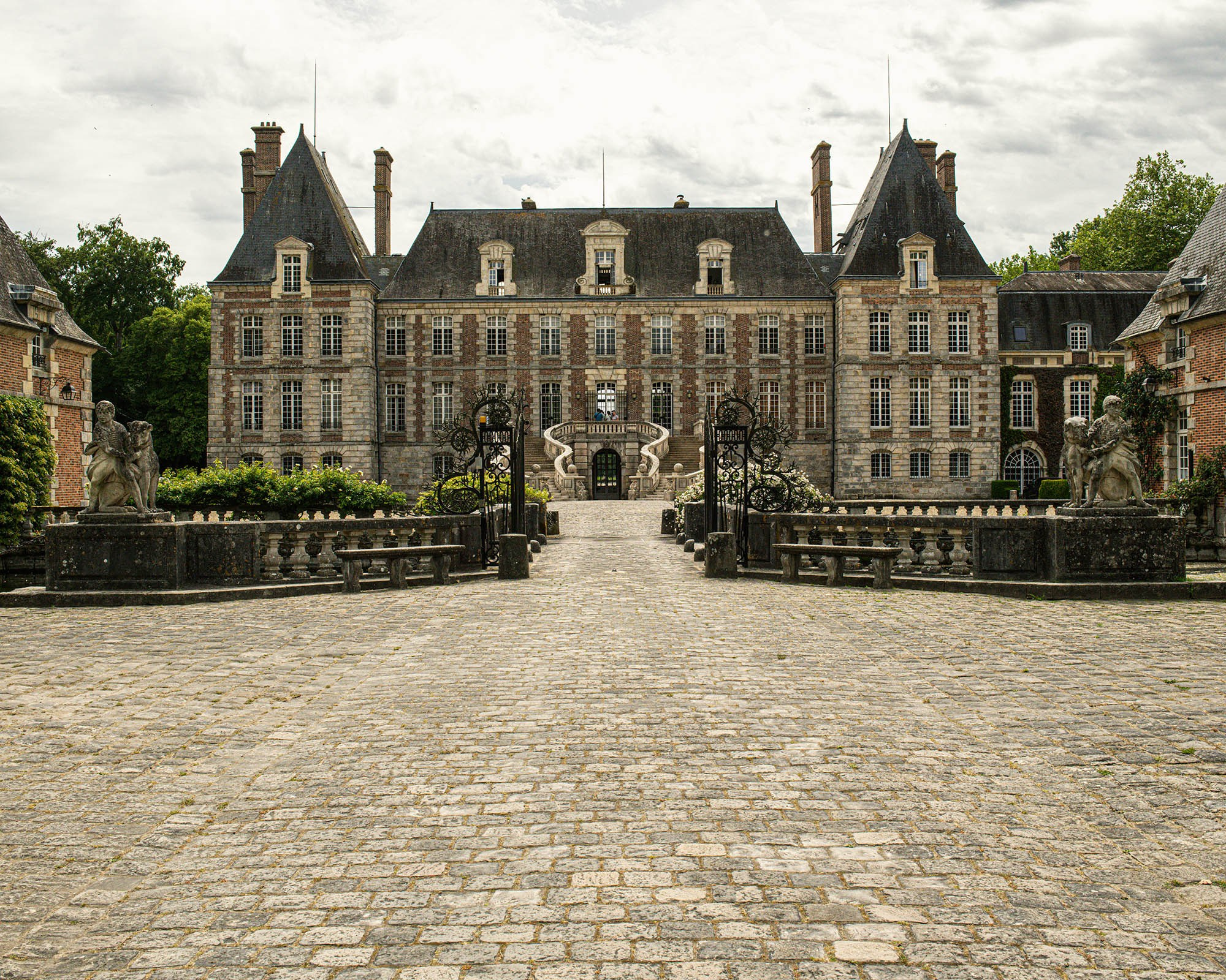 Front view of Château de Courances with historic architecture and stone courtyard in France