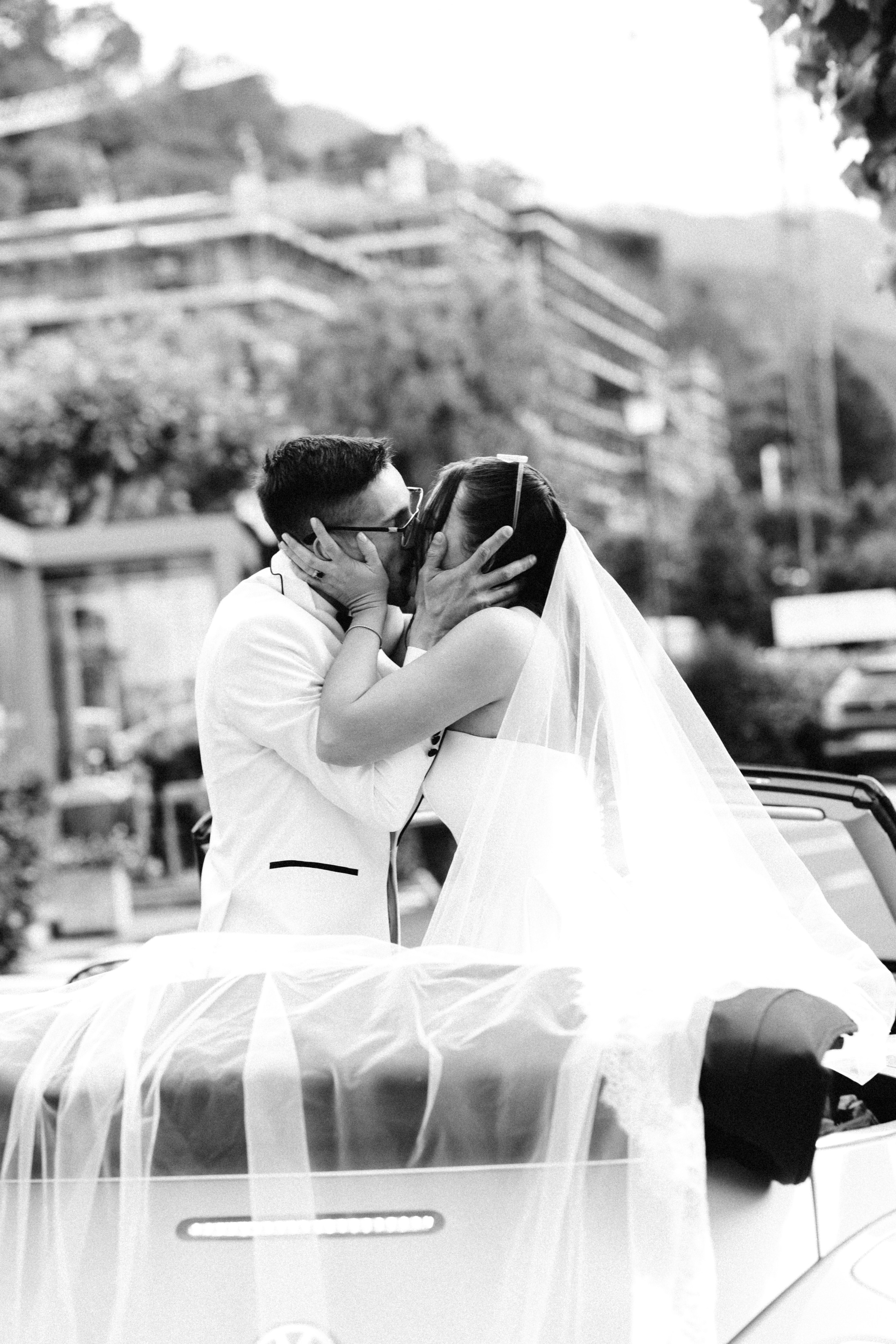 Bride and groom kissing in a vintage convertible after their Bellagio wedding ceremony