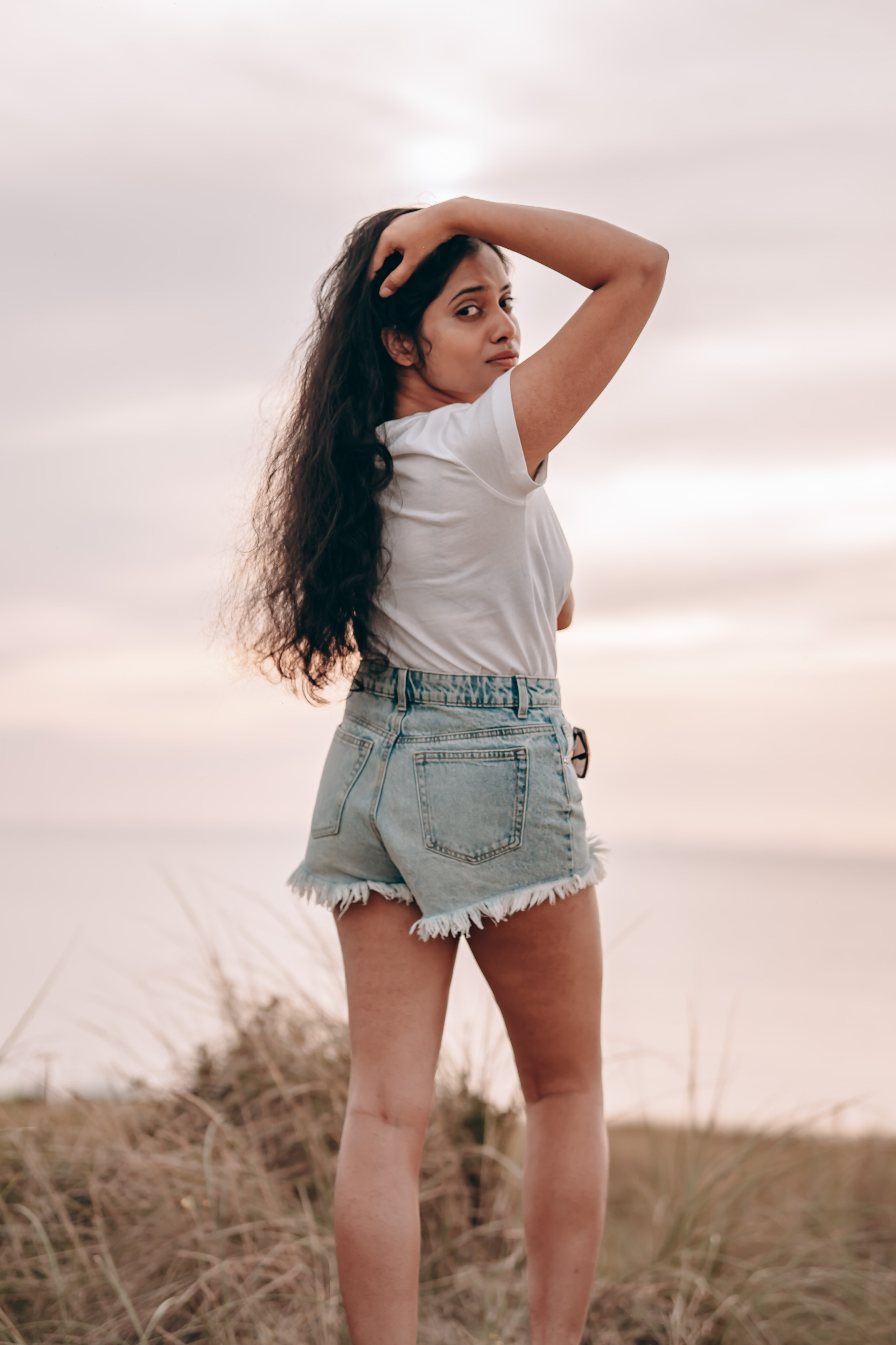 Woman standing at the edge of a hilly area