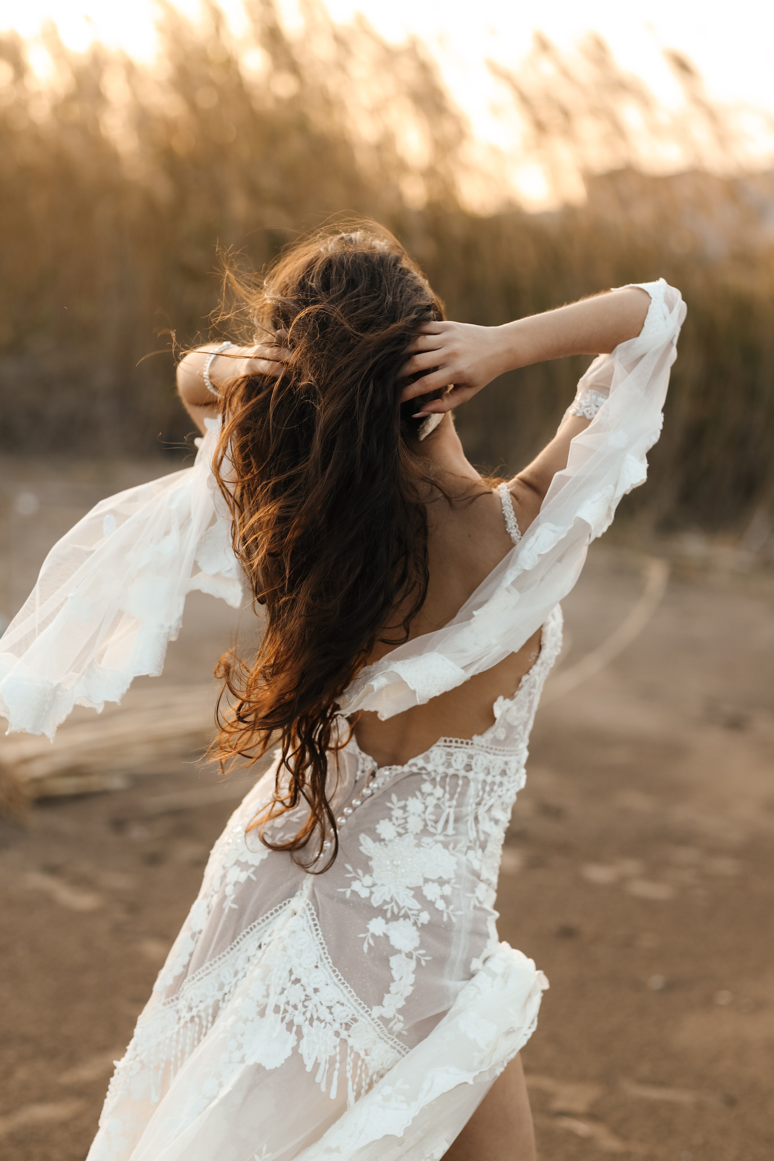 A portrait of girl in a wedding dress on a sunset background in reeds. Rhodes, Greece