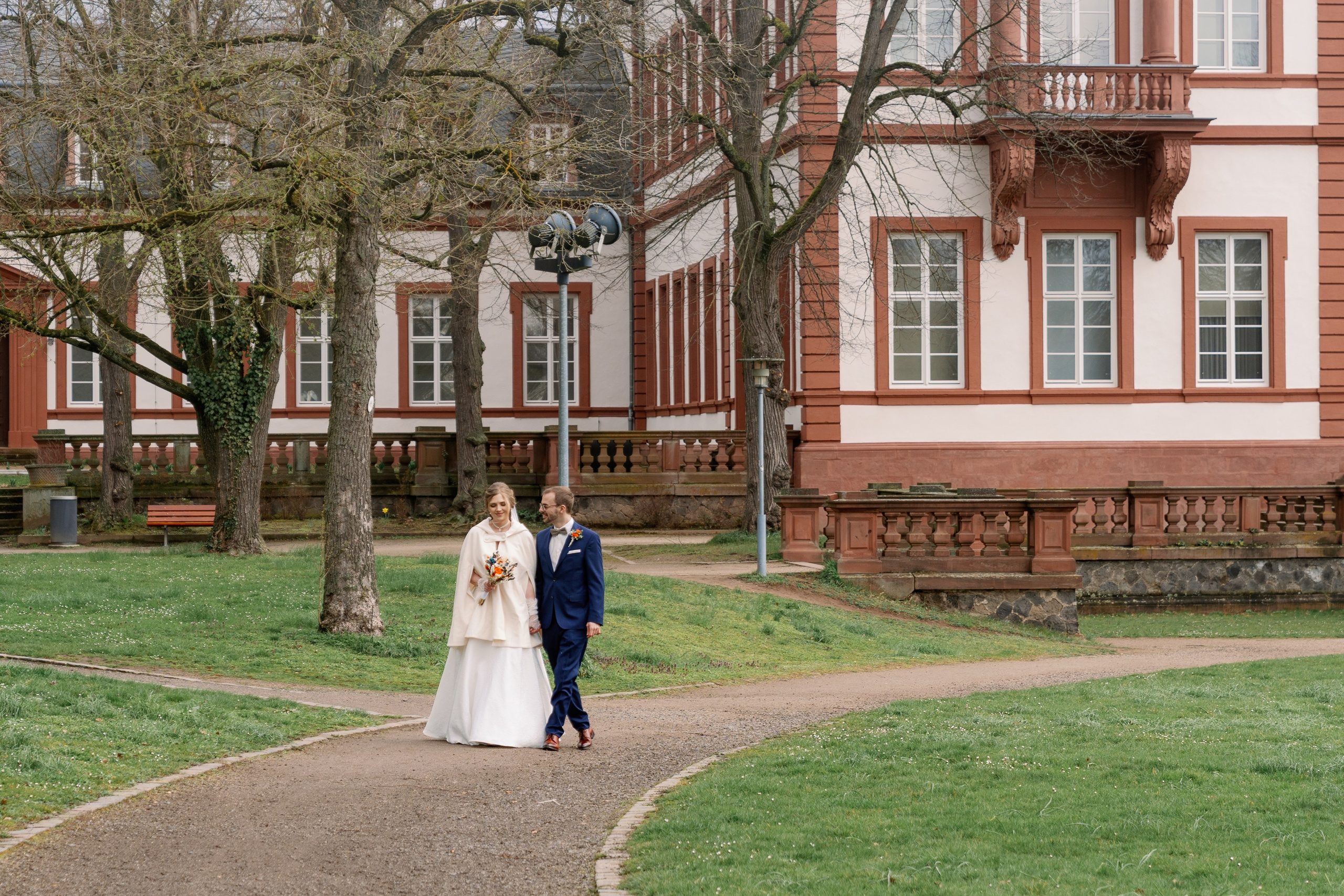 Brautpaar spaziert durch den Schlosspark von Schloss Philippsruhe