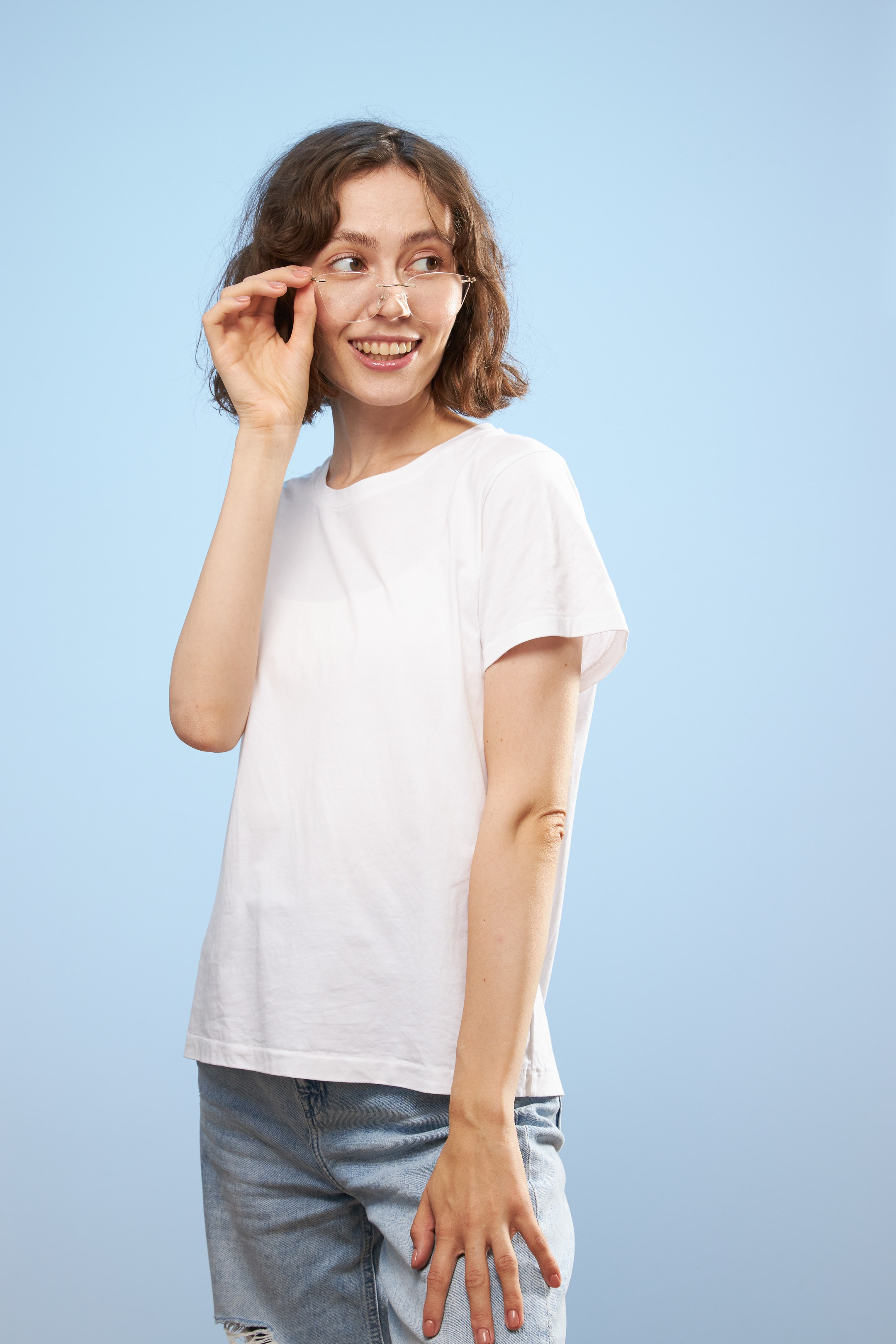 Eyewear model photoshoot - studio portrait of a young lady on light blue background - photographer Andrey Dunin