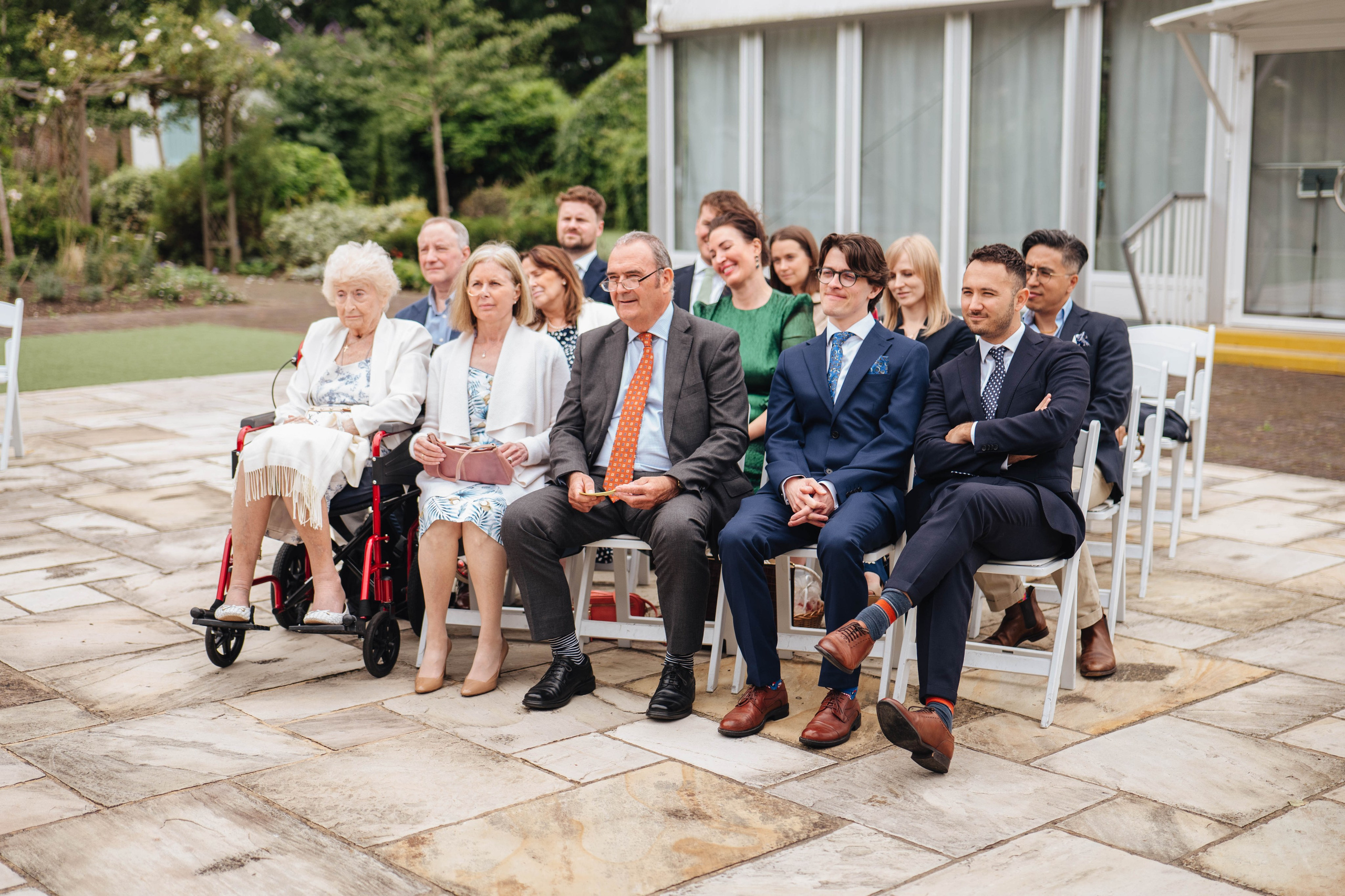 a group photo of family and friends sitting during the wedding ceremony