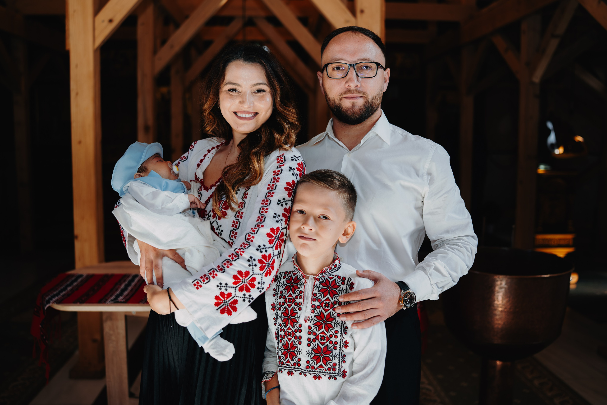 Poză de grup semnificativă la botezul lui Arthur Mihail: nașii și fiul lor adolescen/tânăr stau împreună cu pruncul, într-o imagine care simbolizează întreaga lor familie unită în această nouă responsabilitate de ghidare spirituală.